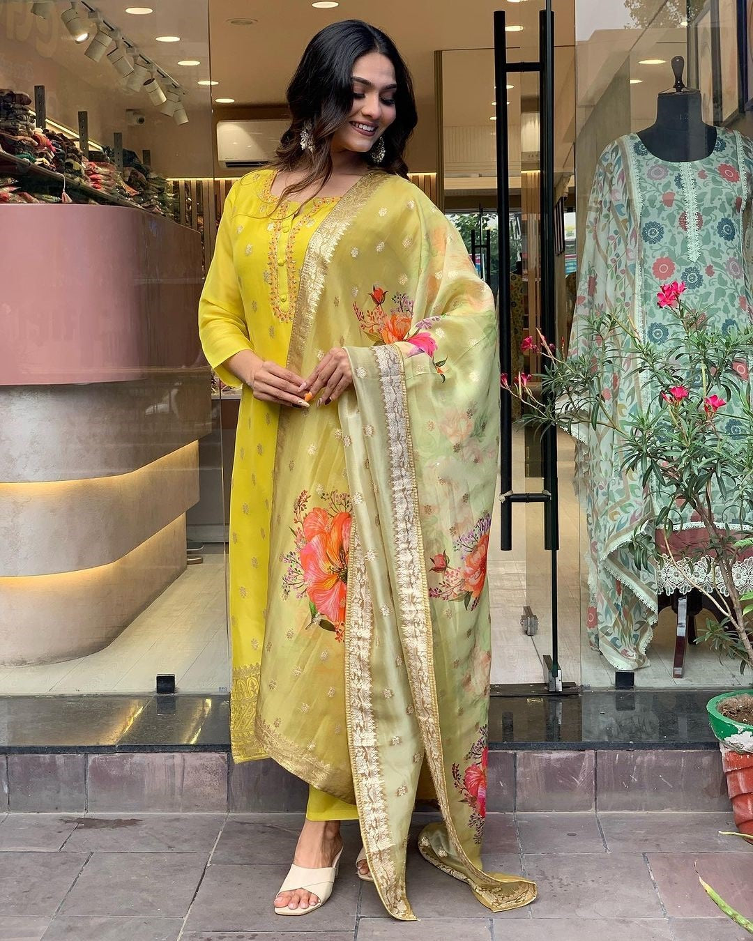 Model in vibrant yellow kurti with intricate gold embroidery and a multi-floral print dupatta draped elegantly.
