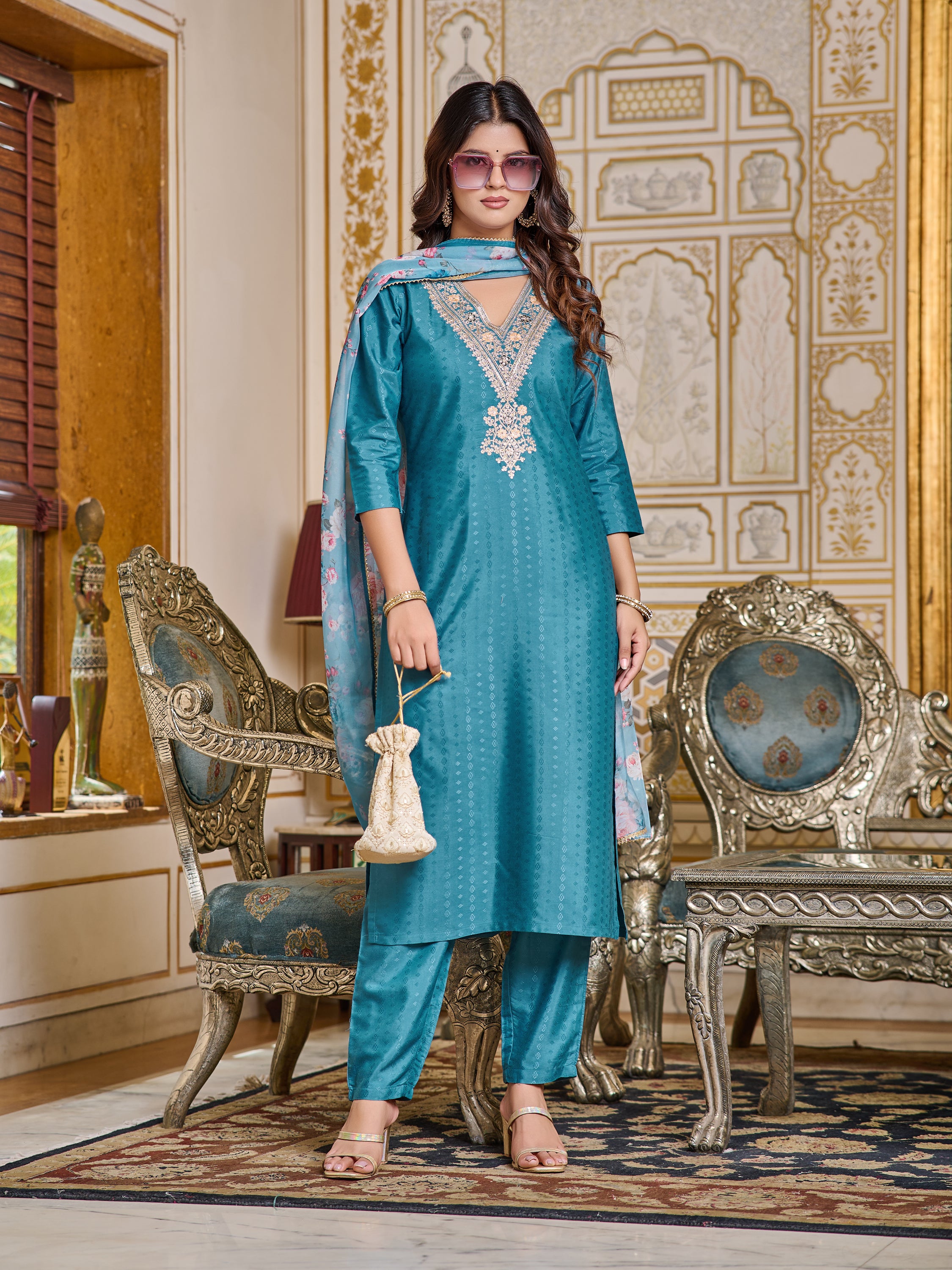 Model posing with sunglasses and a potli bag, showcasing a stylish, accessorized look with the teal kurta set.