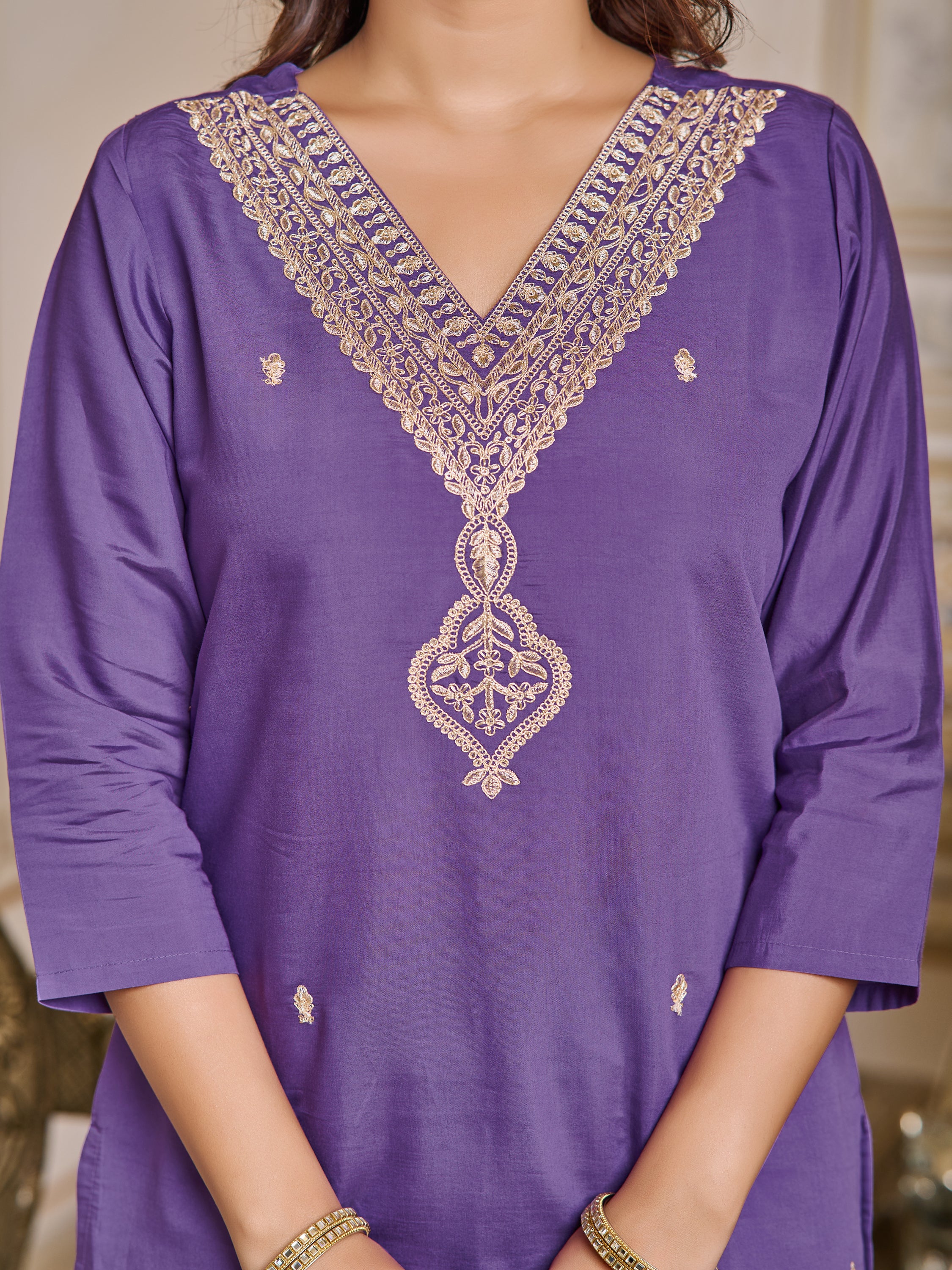 Close-up of the intricate gold embroidery on the V-neckline of the purple chanderi kurti.