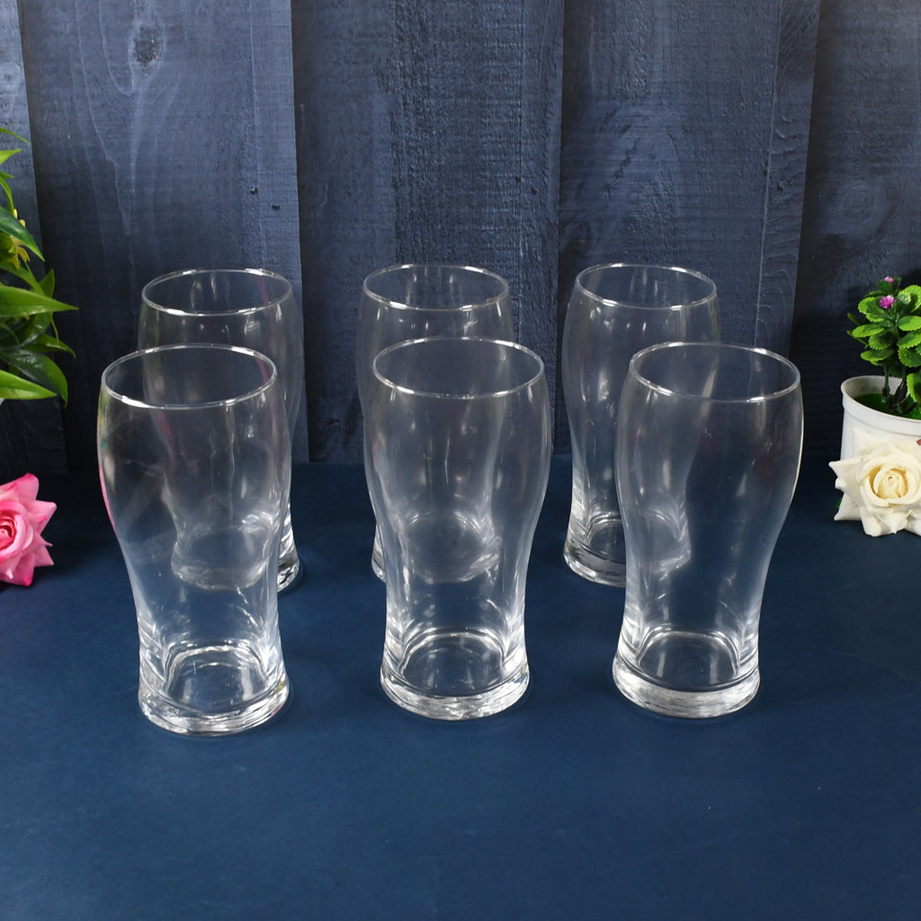 Close-up of the thick, sturdy base of a clear glass tumbler filled with sparkling water.