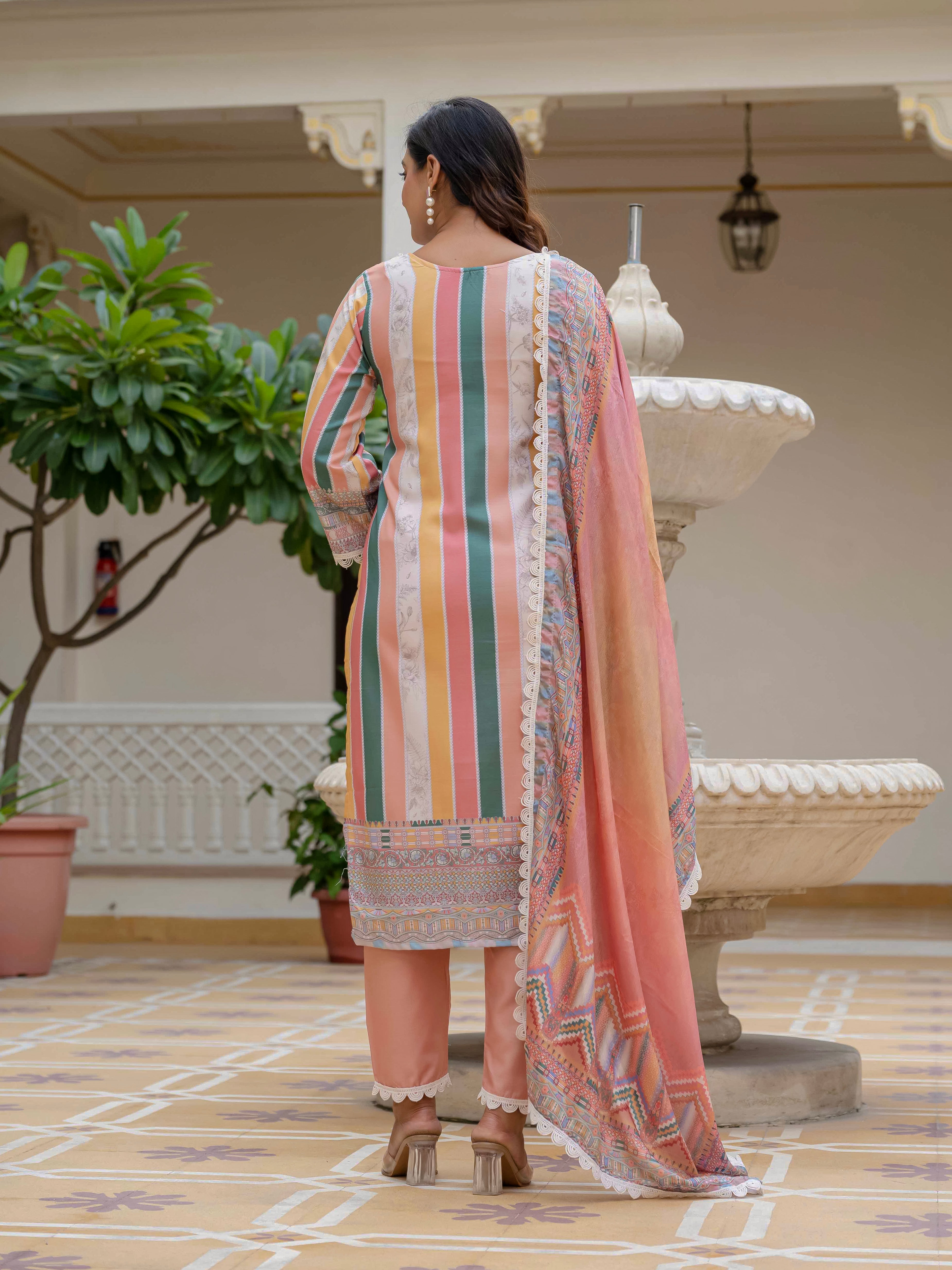 Back view of model wearing Laila Orange Kurta Set, featuring striped kurta and matching pants with chinon dupatta in a courtyard.
