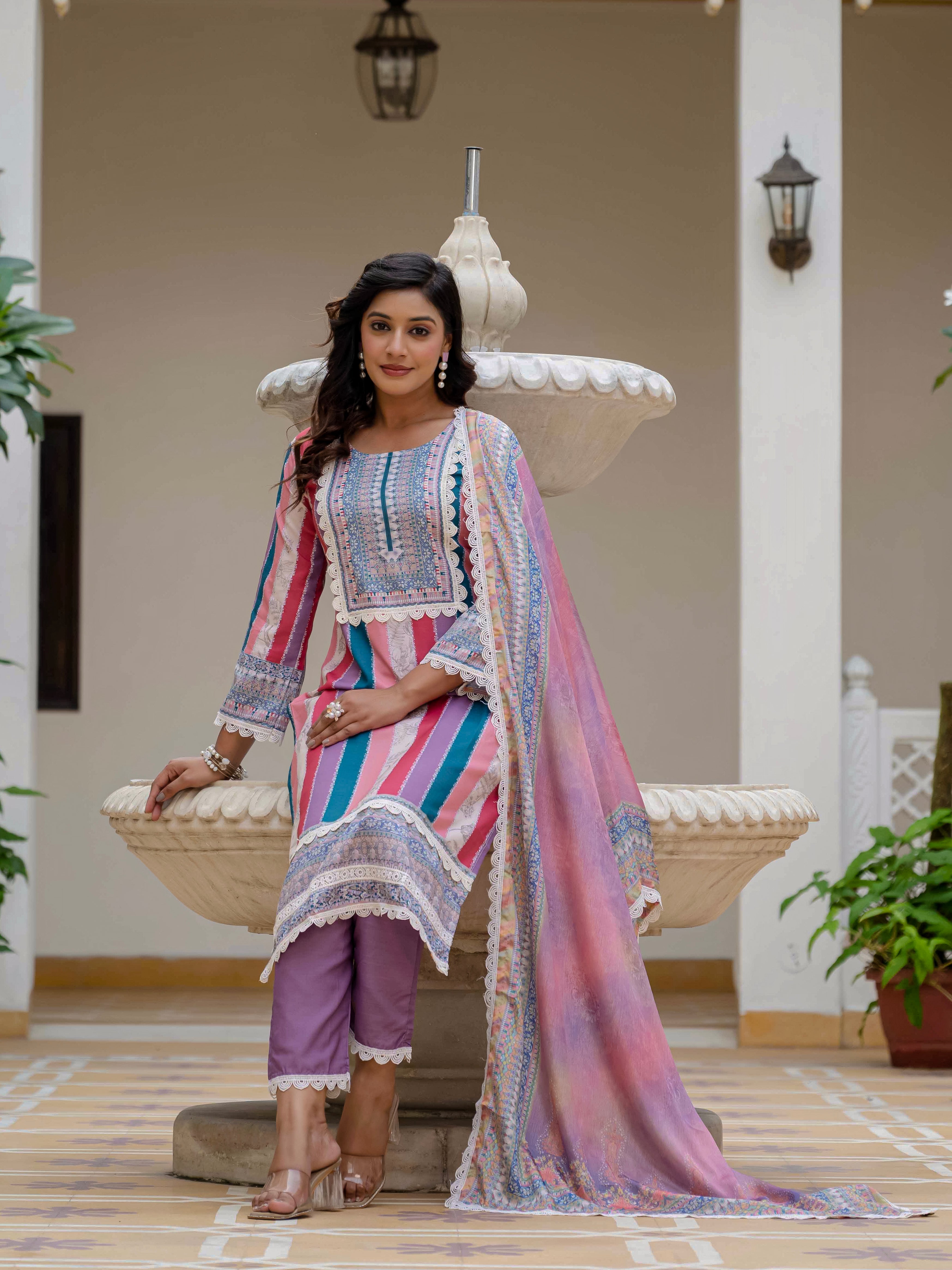 Model seated on a fountain ledge in Laila Pink Kurta Set, displaying the outfit's comfortable elegance and drape.