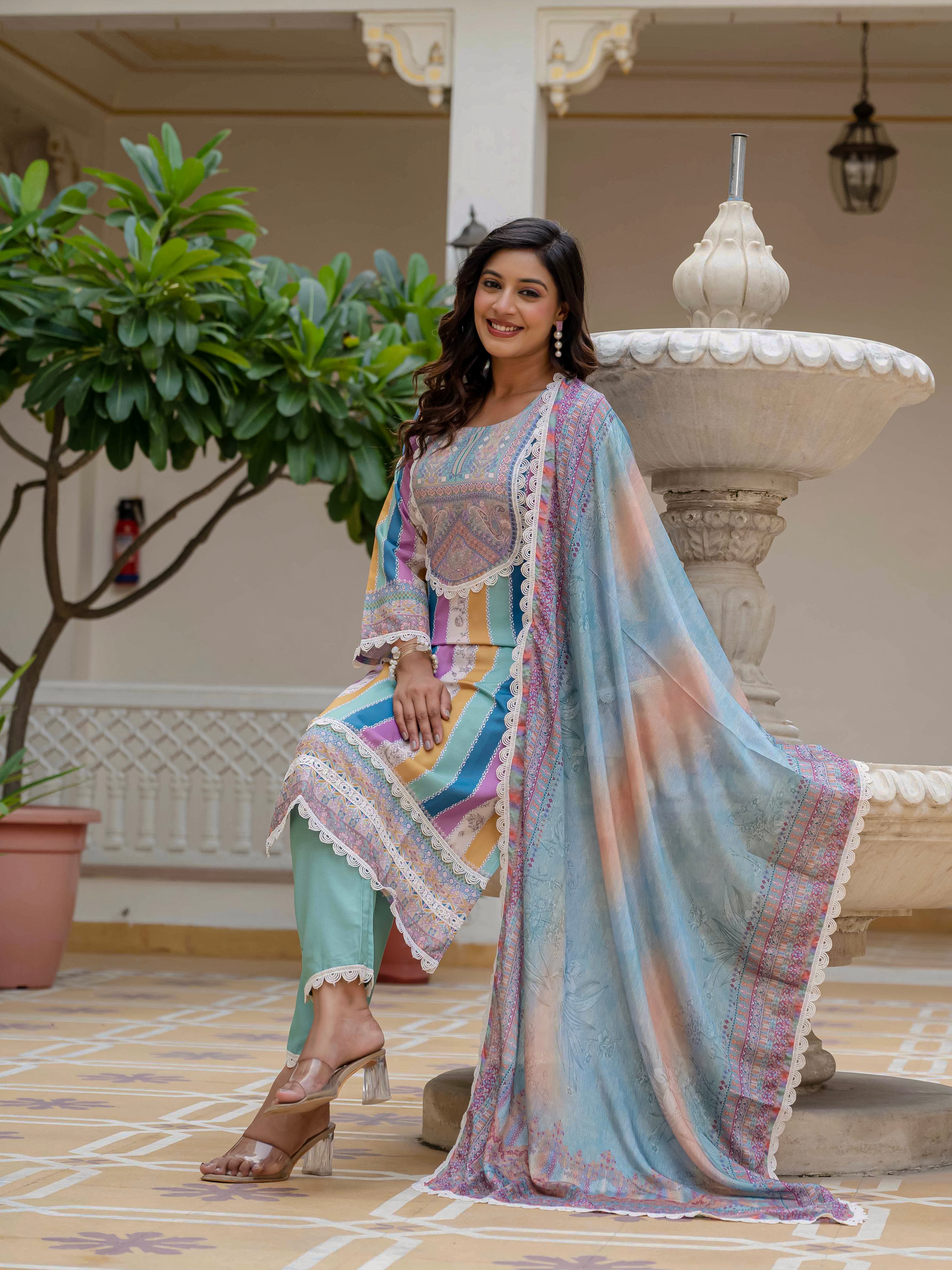 Model seated on fountain ledge in Laila Sky Kurta Set, displaying the complete three-piece ensemble in a relaxed pose.