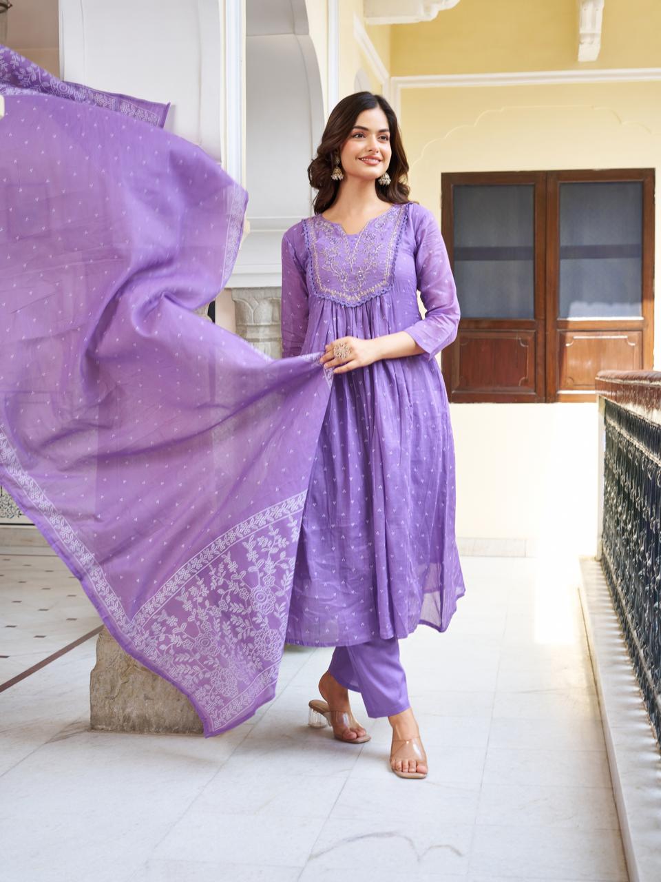 Model standing and smiling in a lavender kurti set, with the printed dupatta flowing dynamically, emphasizing the soft movement.