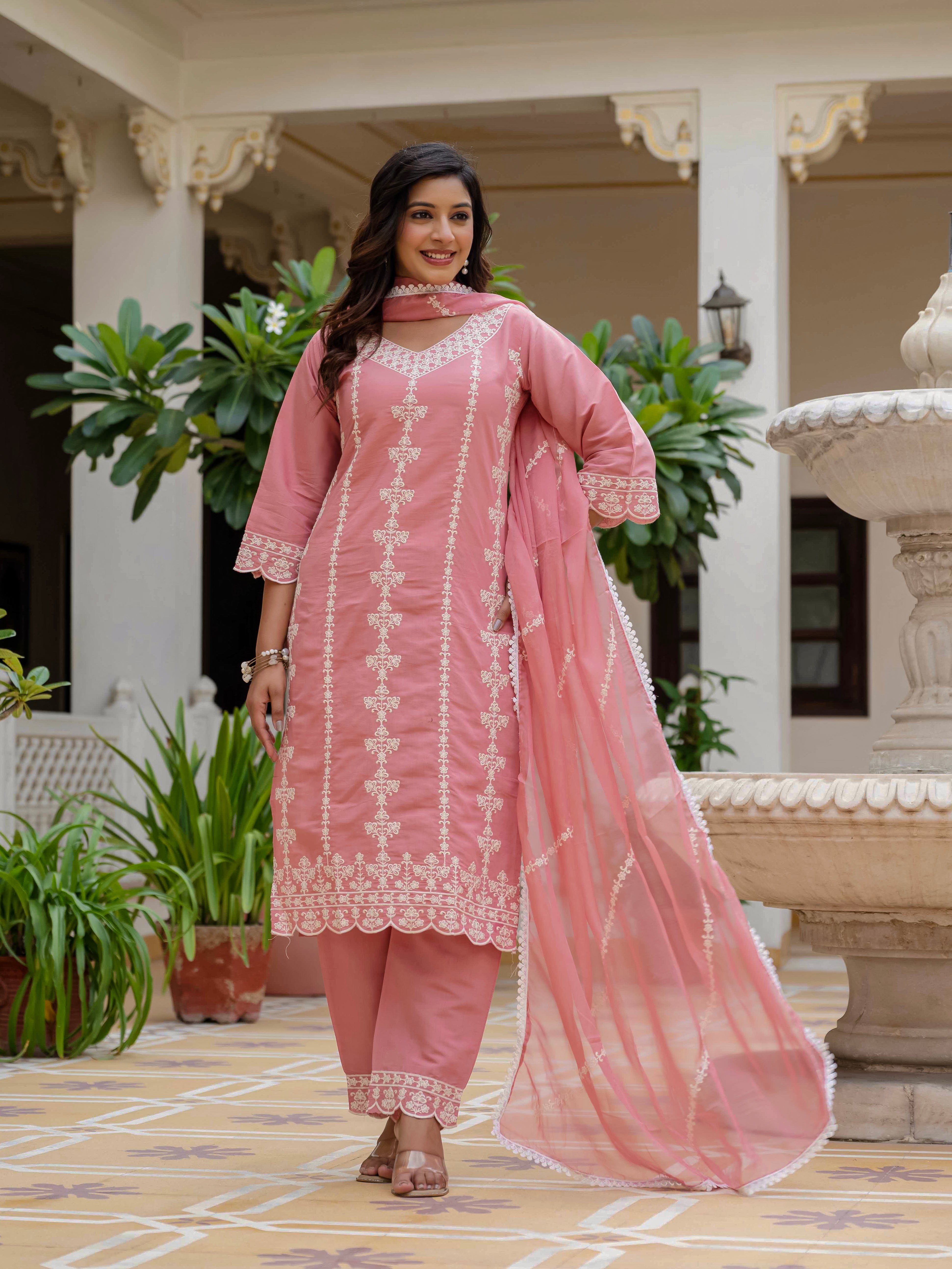 Smiling woman in a rose pink embroidered kurti set, emphasizing the comfortable fit and exquisite detailing of the ethnic attire's embroidery and fabric.