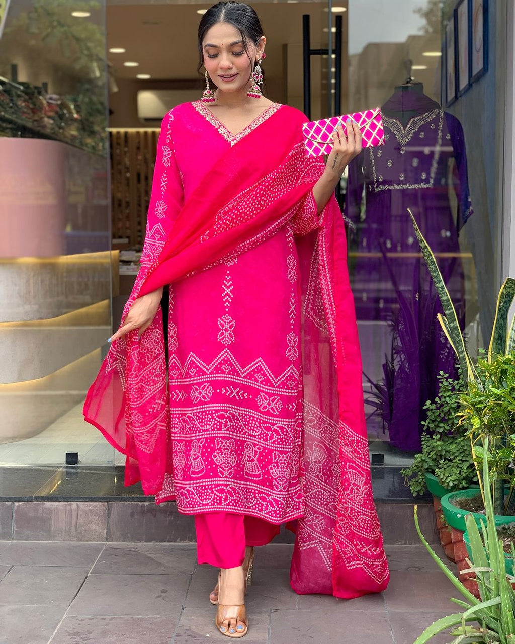TRENDBUY woman gracefully posing in vibrant Rani Pink French Crepe printed kurta set with V-neck embroidery