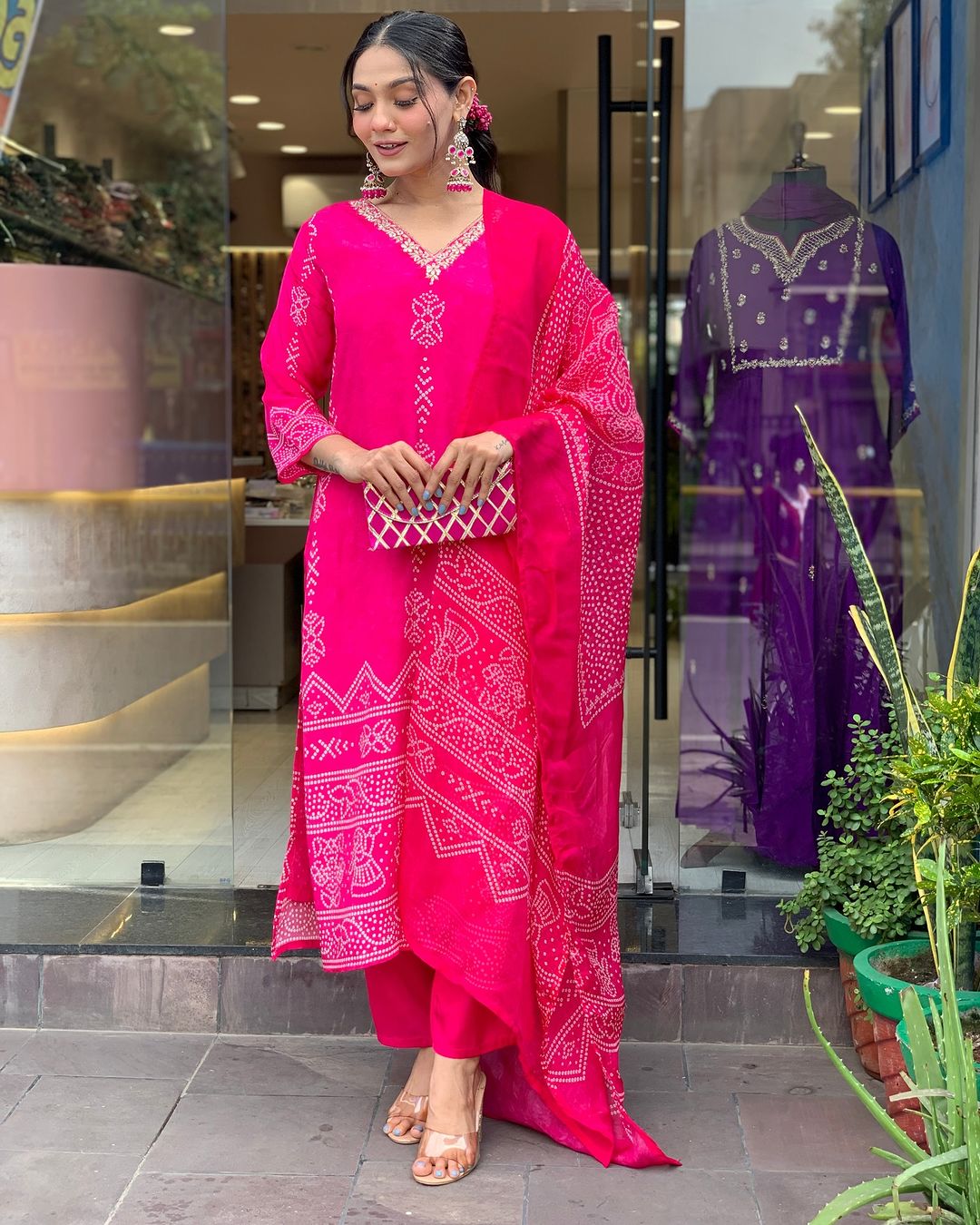 TRENDBUY woman holding a chic clutch, modeling the complete Rani Pink French Crepe printed kurta set