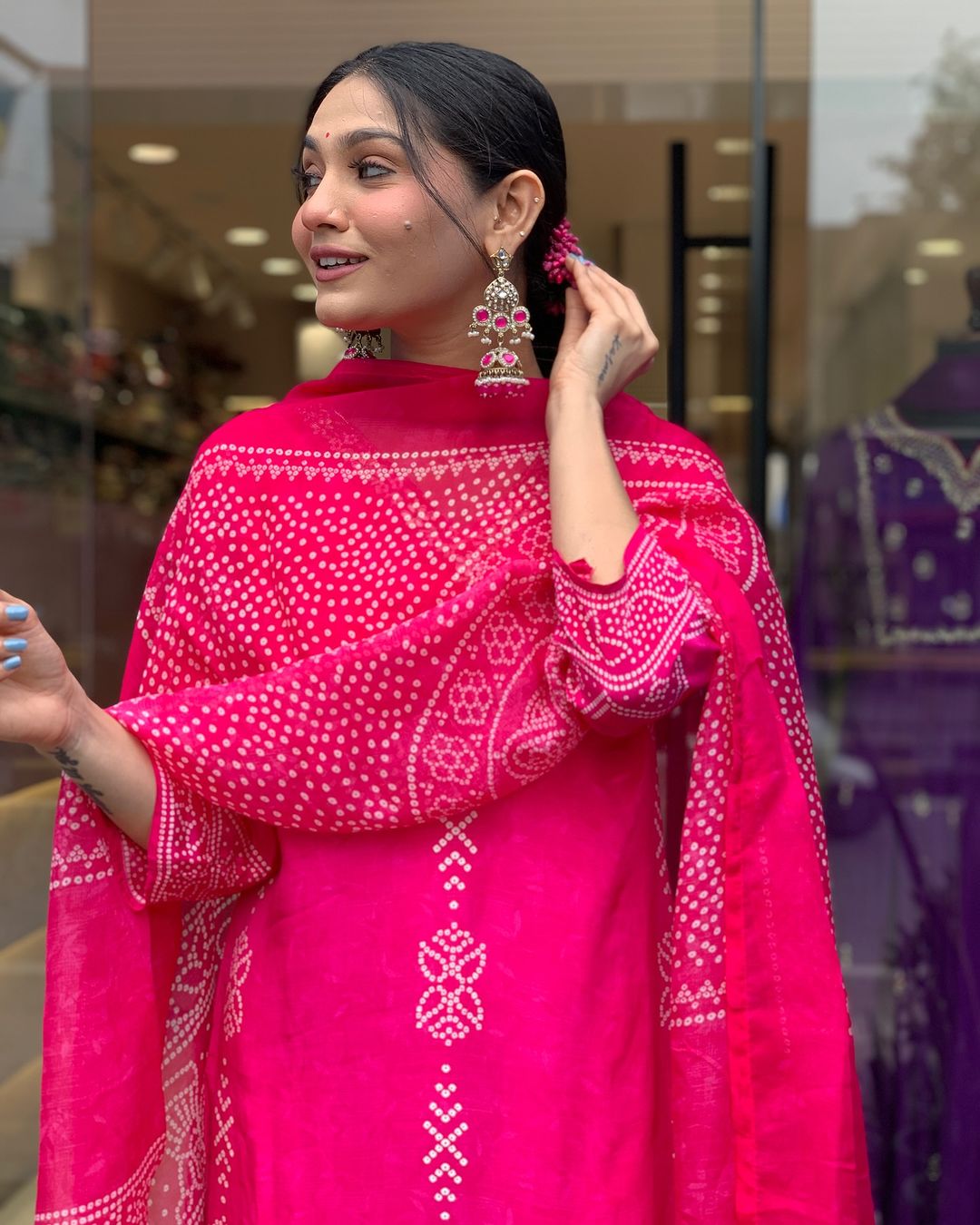 Smiling TRENDBUY model in Rani Pink kurta set, highlighting elegant earrings and printed chinon dupatta