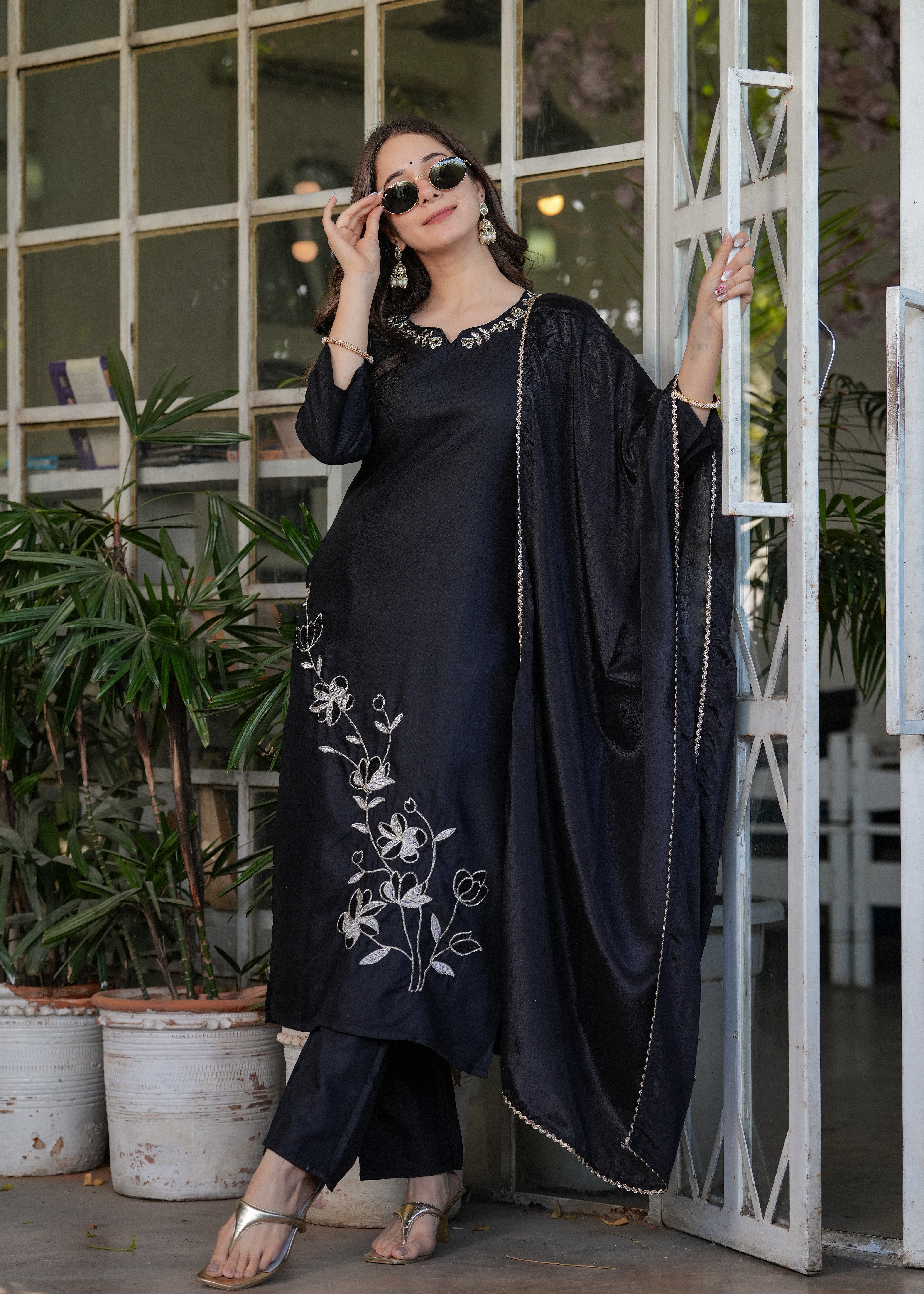Woman in black viscose rayon kurta set with white floral embroidery, black chinon dupatta, and sunglasses, posing outdoors at TRENDBUY.