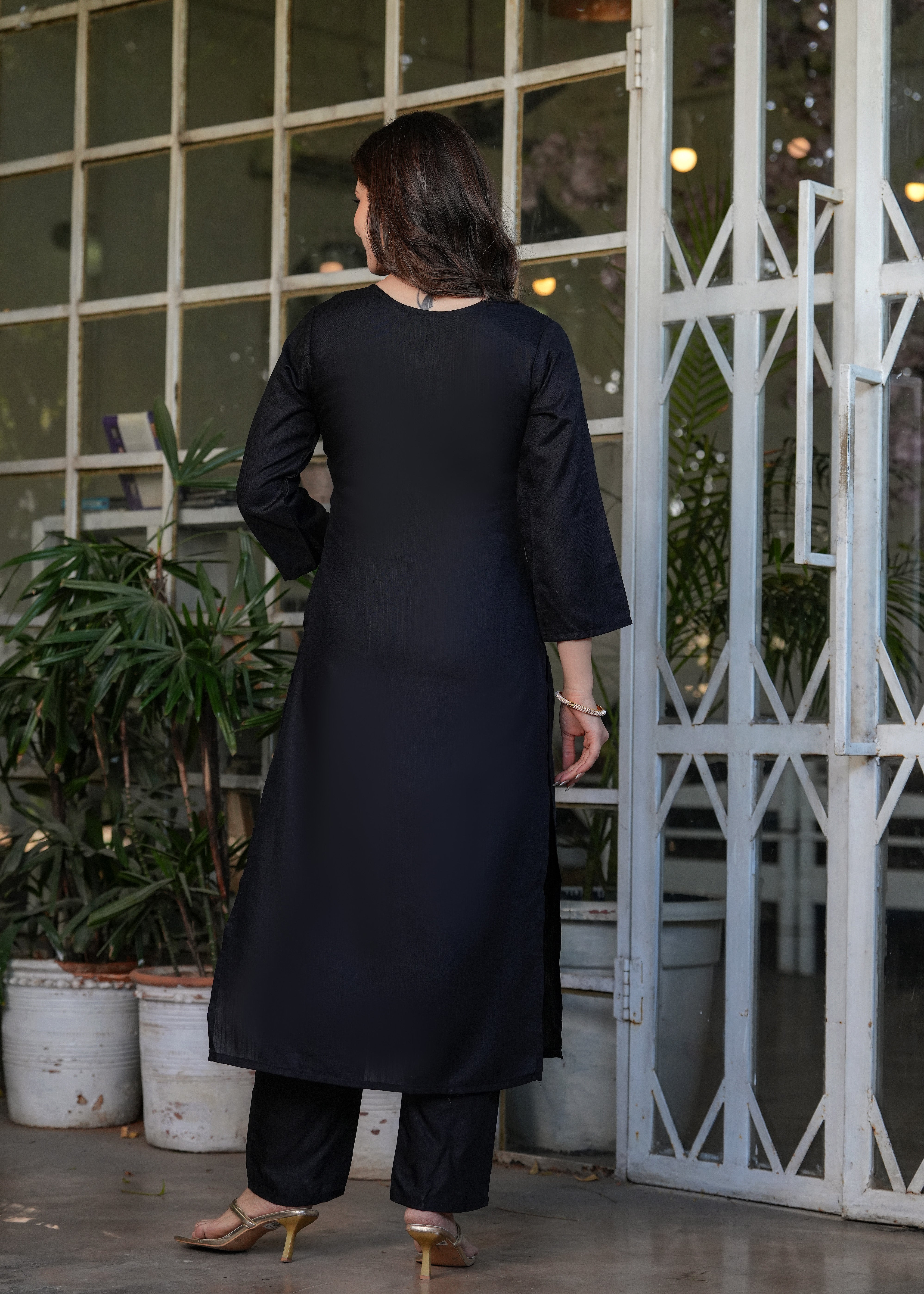 Rear view of woman in black straight cut kurta and pants, showing the plain back design of the TRENDBUY ensemble.