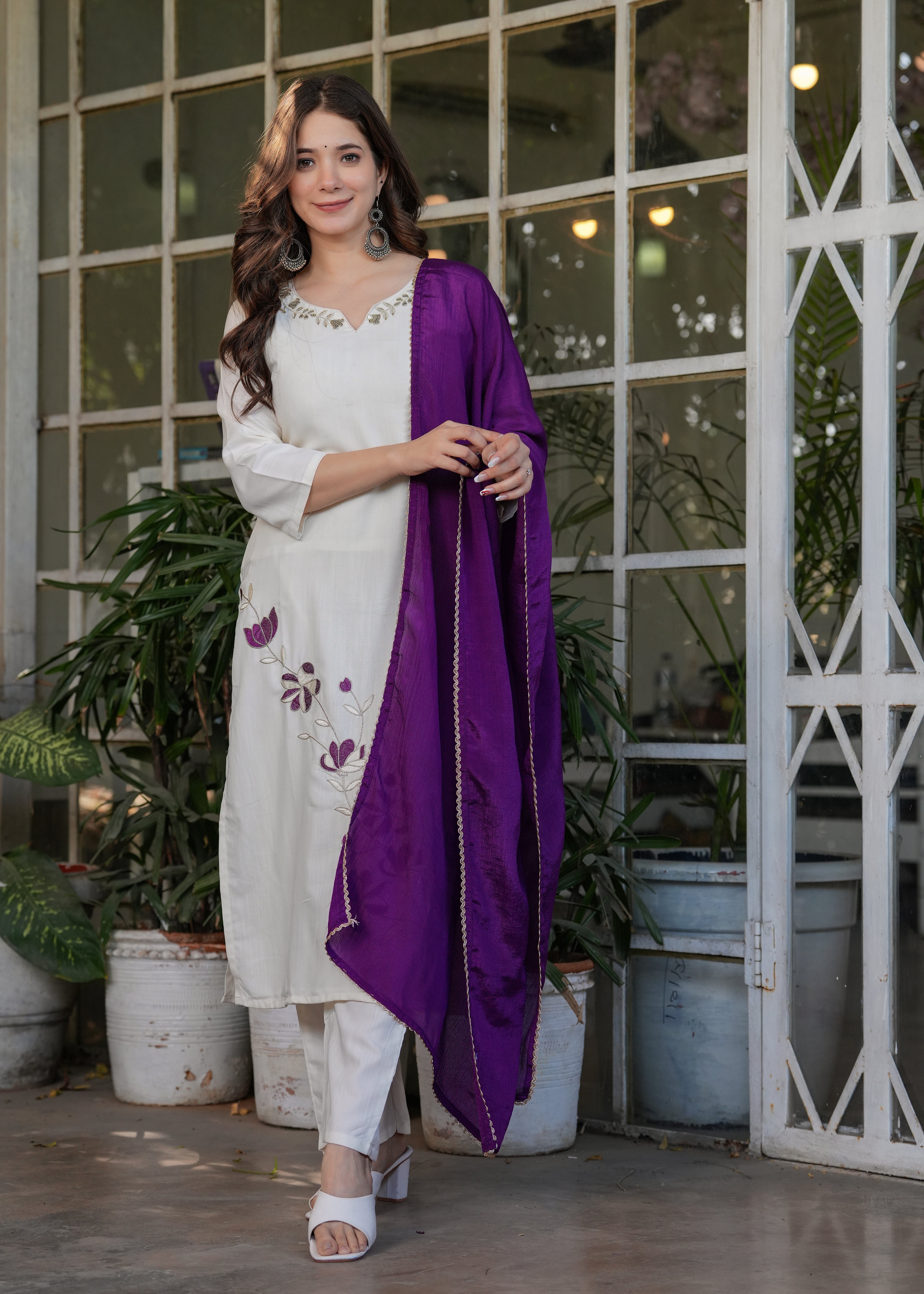 Woman in off-white viscose rayon kurta set with purple floral embroidery and contrasting purple chinon dupatta, a chic TRENDBUY choice.