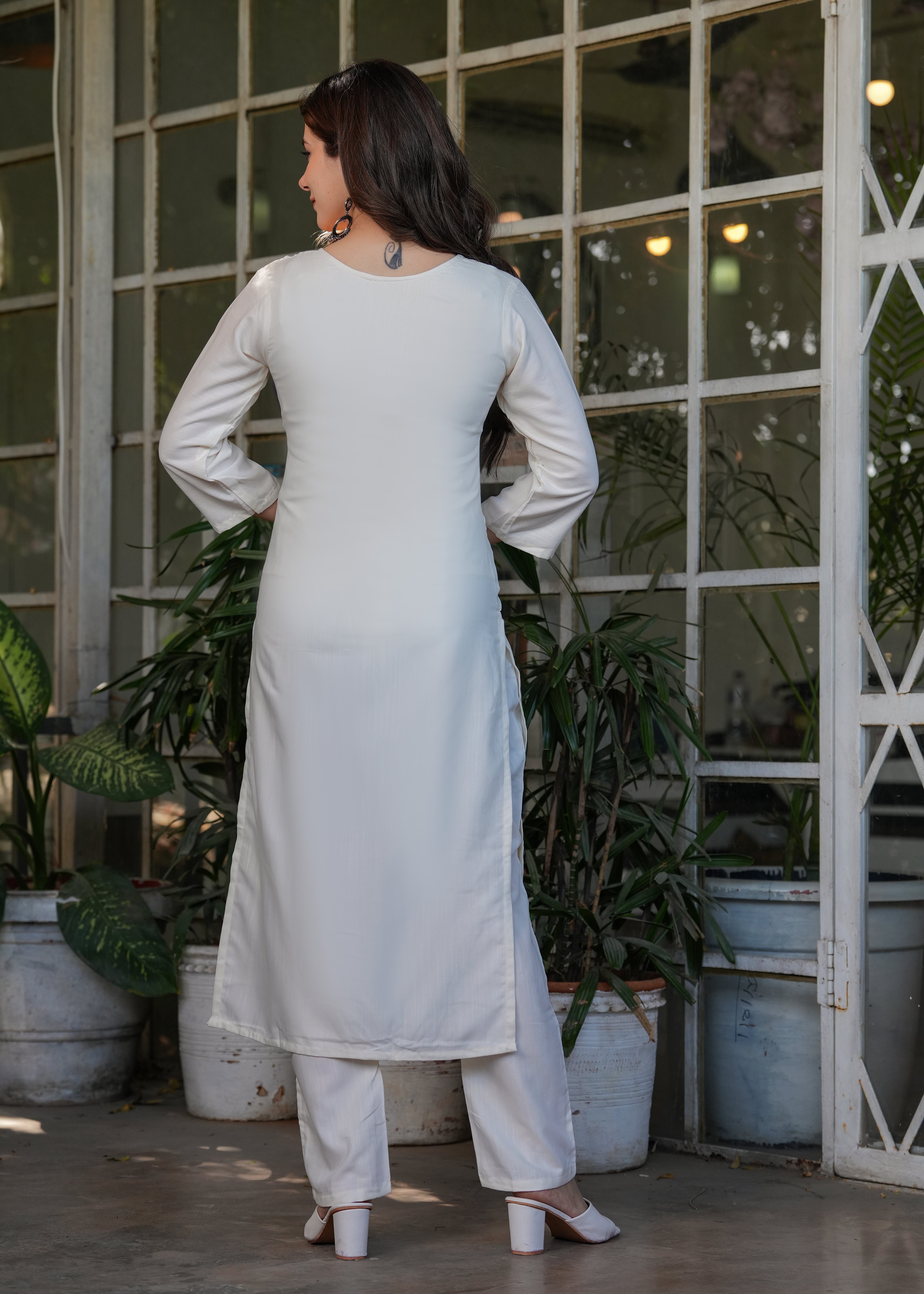 Rear view of woman in off-white straight cut kurta and matching pants, highlighting the simplicity of the back design.