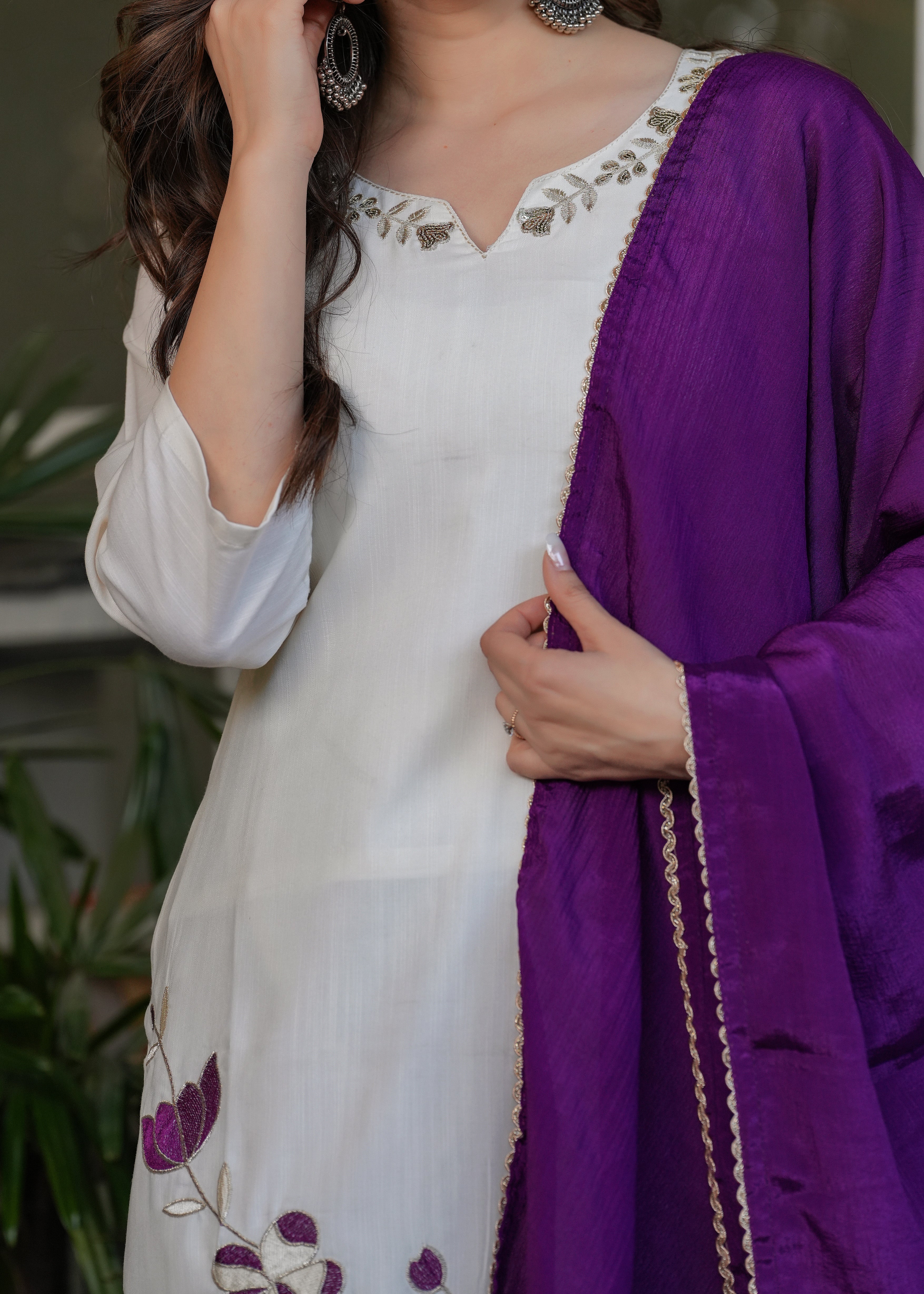 Detail shot of TRENDBUY's off-white kurta with purple floral embroidery and the gold-bordered purple dupatta.