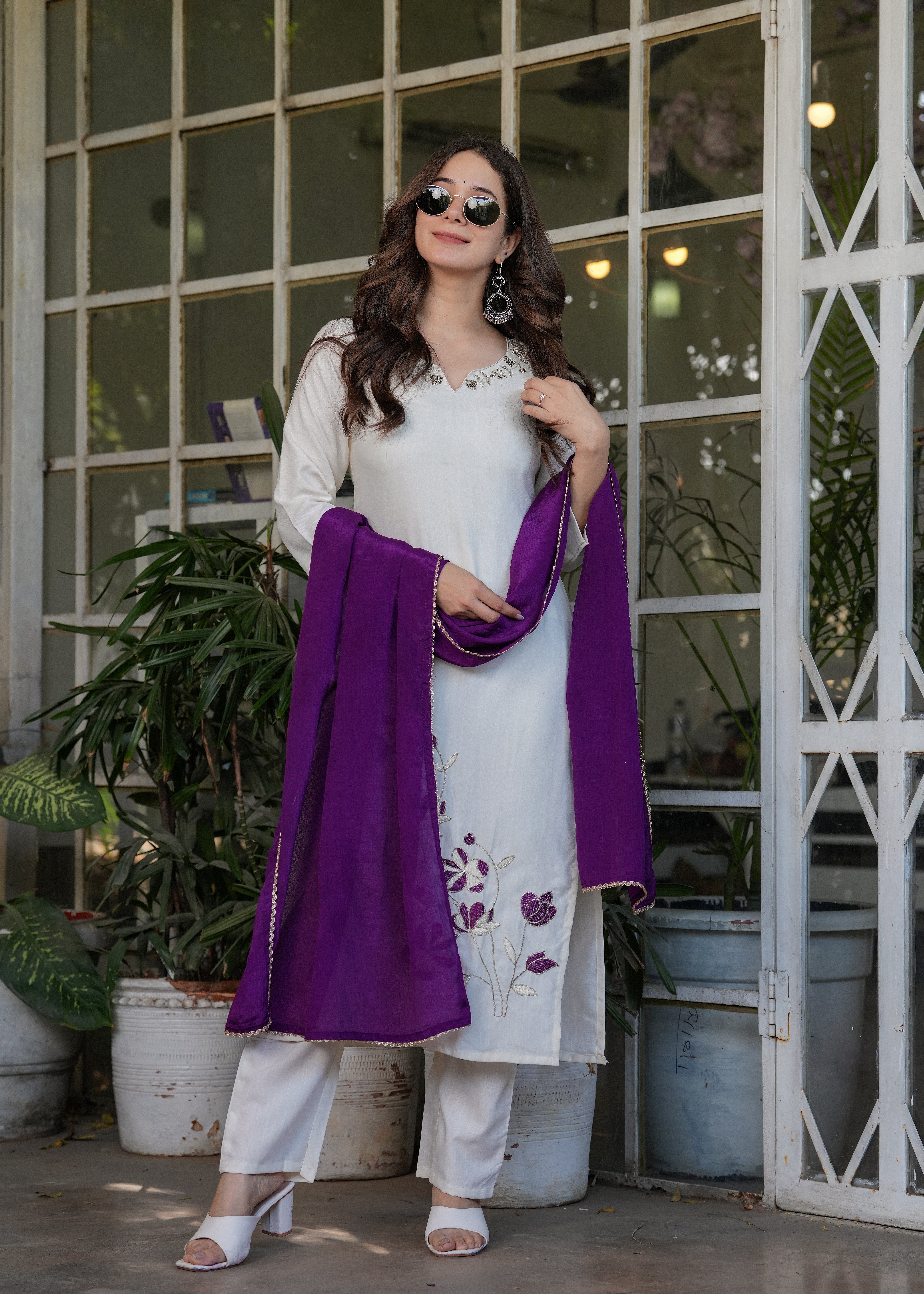 Woman in off-white kurta set with purple embroidery and a beautiful purple dupatta, smiling for TRENDBUY.