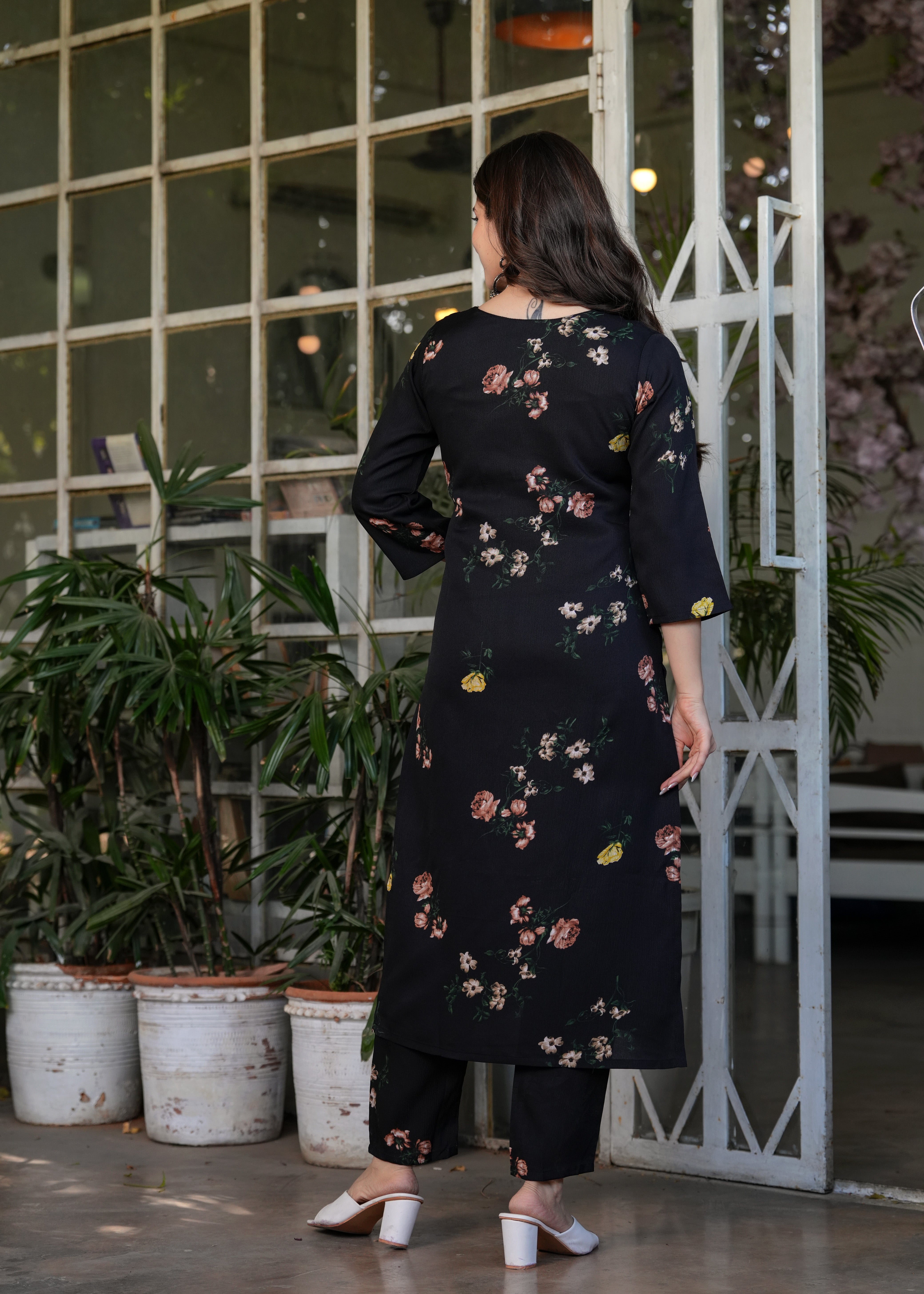 Rear view of the woman in the black silk blend printed kurti and pants, showing the full length and back design of the outfit.