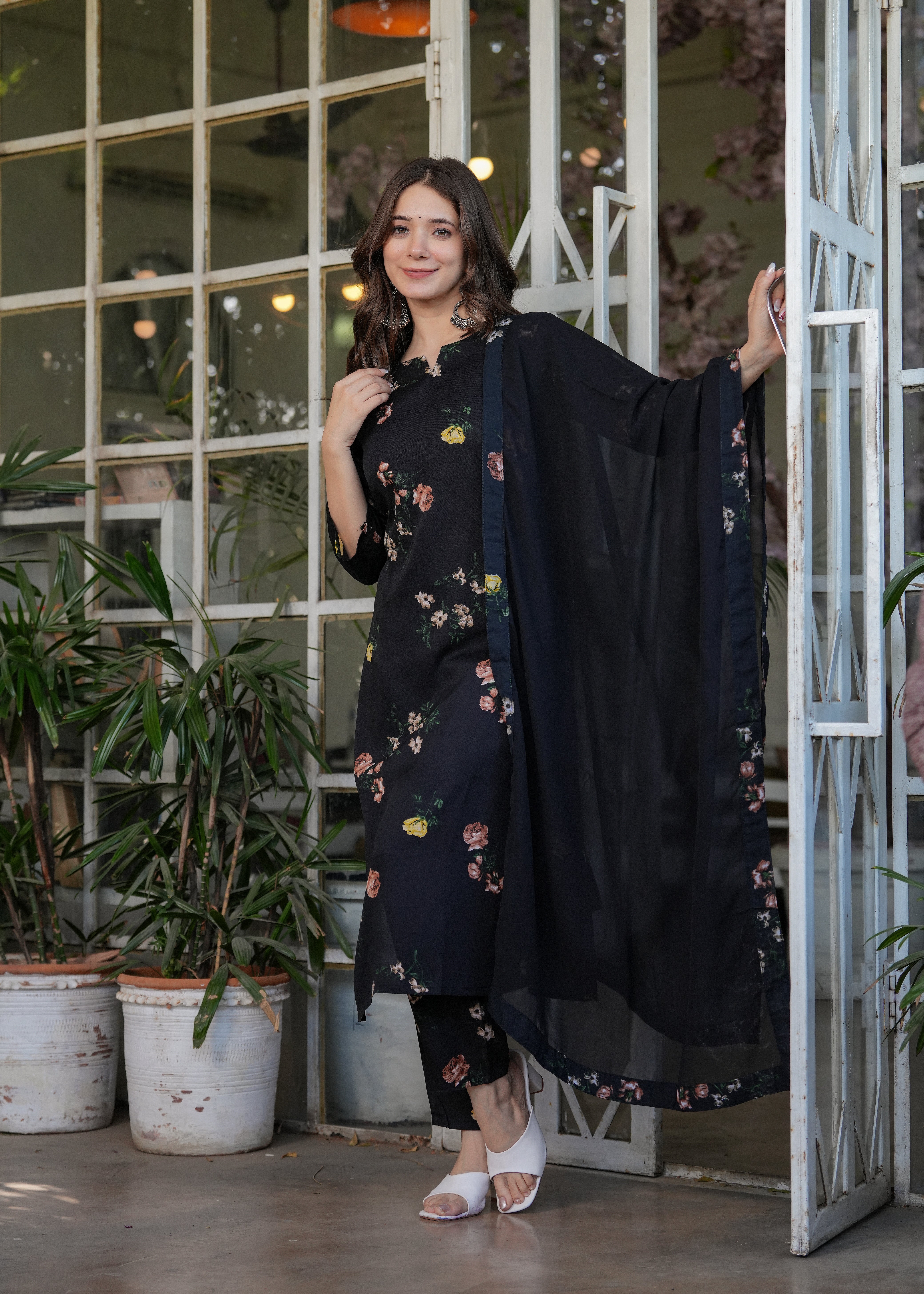 Smiling woman modeling a black silk blend printed kurti set, displaying the comfortable fit and the graceful drape of the Nazmeen dupatta.