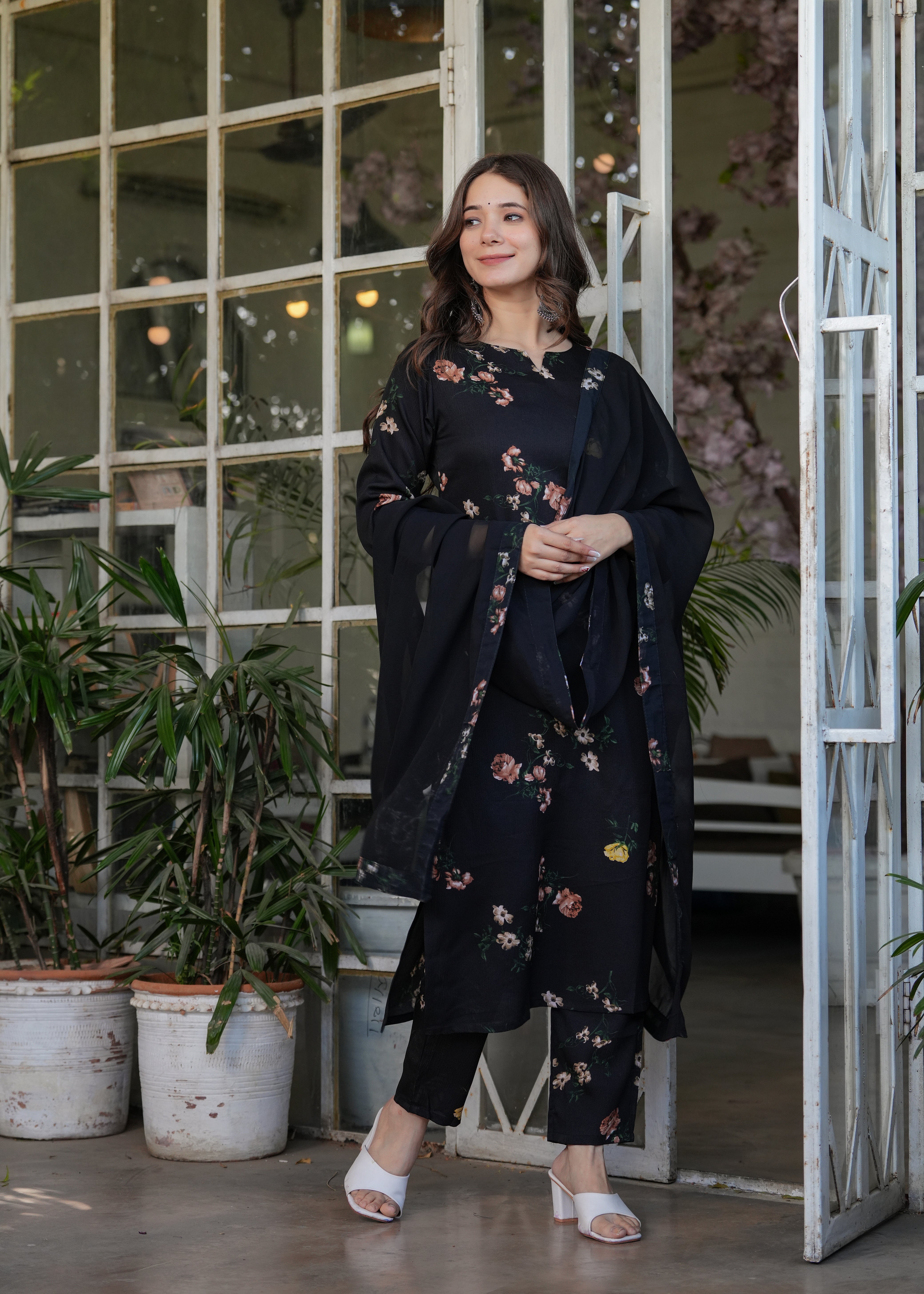 Stylish woman in a black silk blend printed kurta and pants with dupatta, demonstrating the outfit's movement and elegant silhouette.
