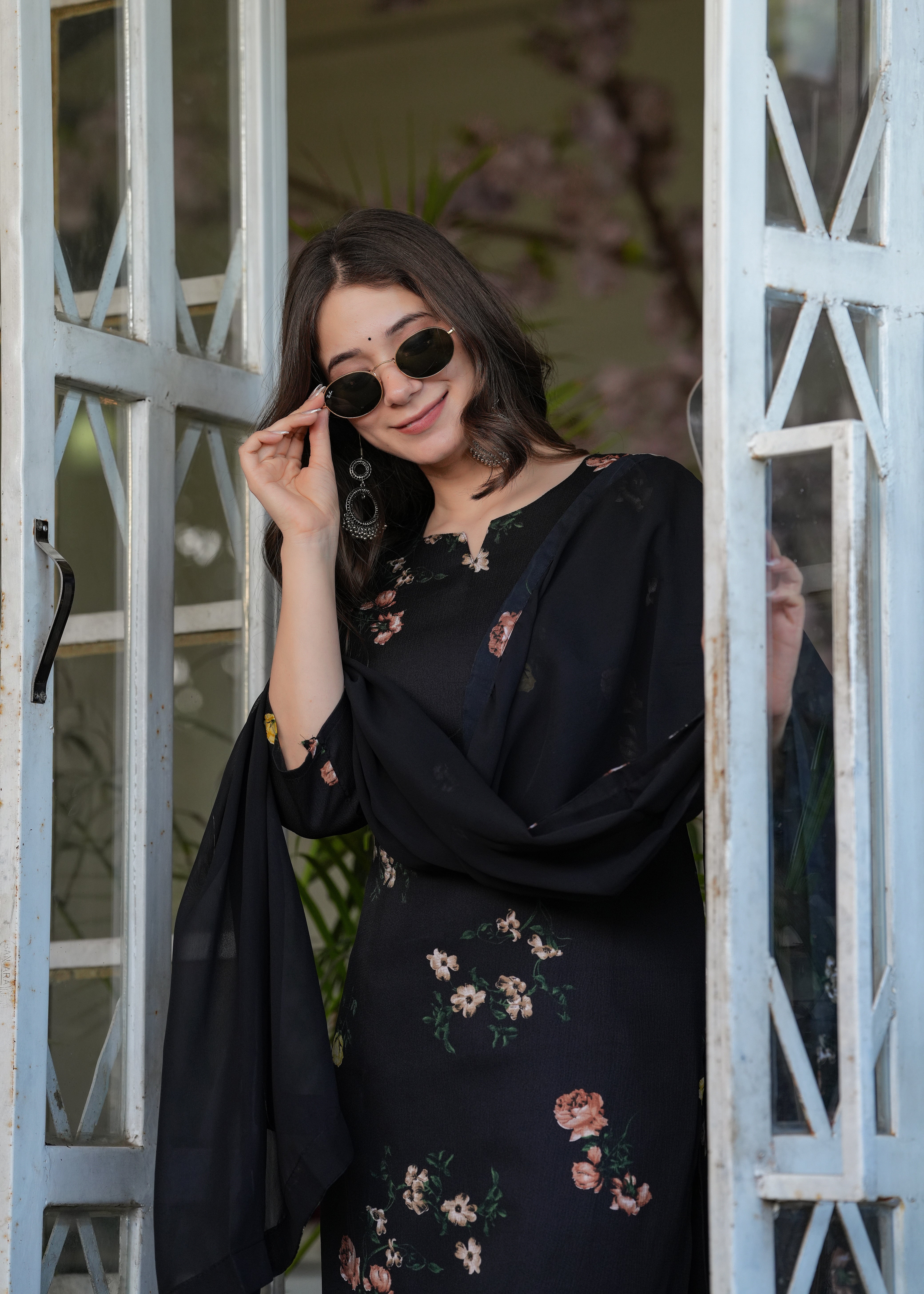 Close-up portrait of the woman in the black silk blend printed kurti, highlighting her face, earrings, and the kurti's neckline and print detail.