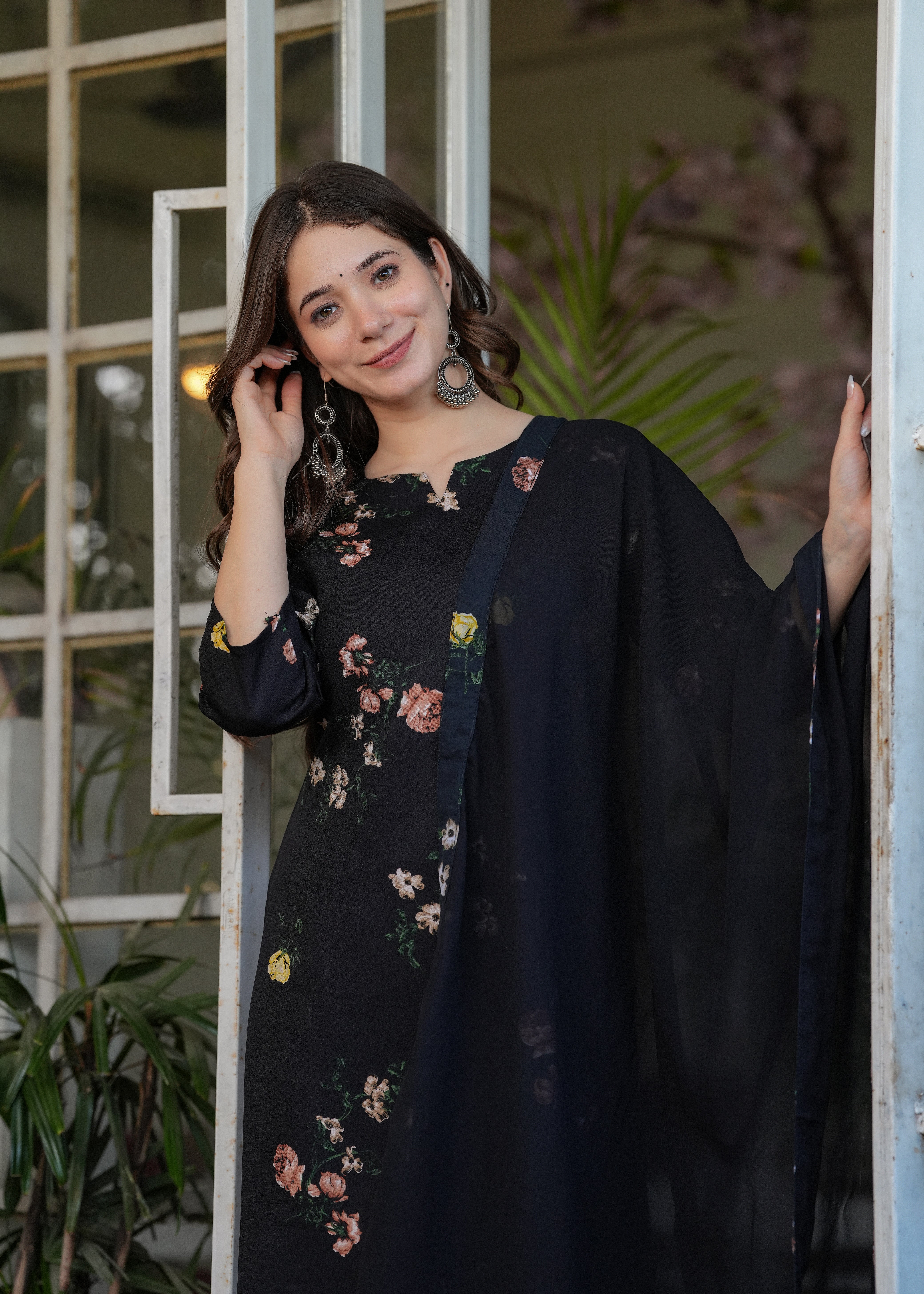 Smiling woman showcasing the comfortable fit and elegant design of the black silk blend printed kurti set, with focus on the top half.