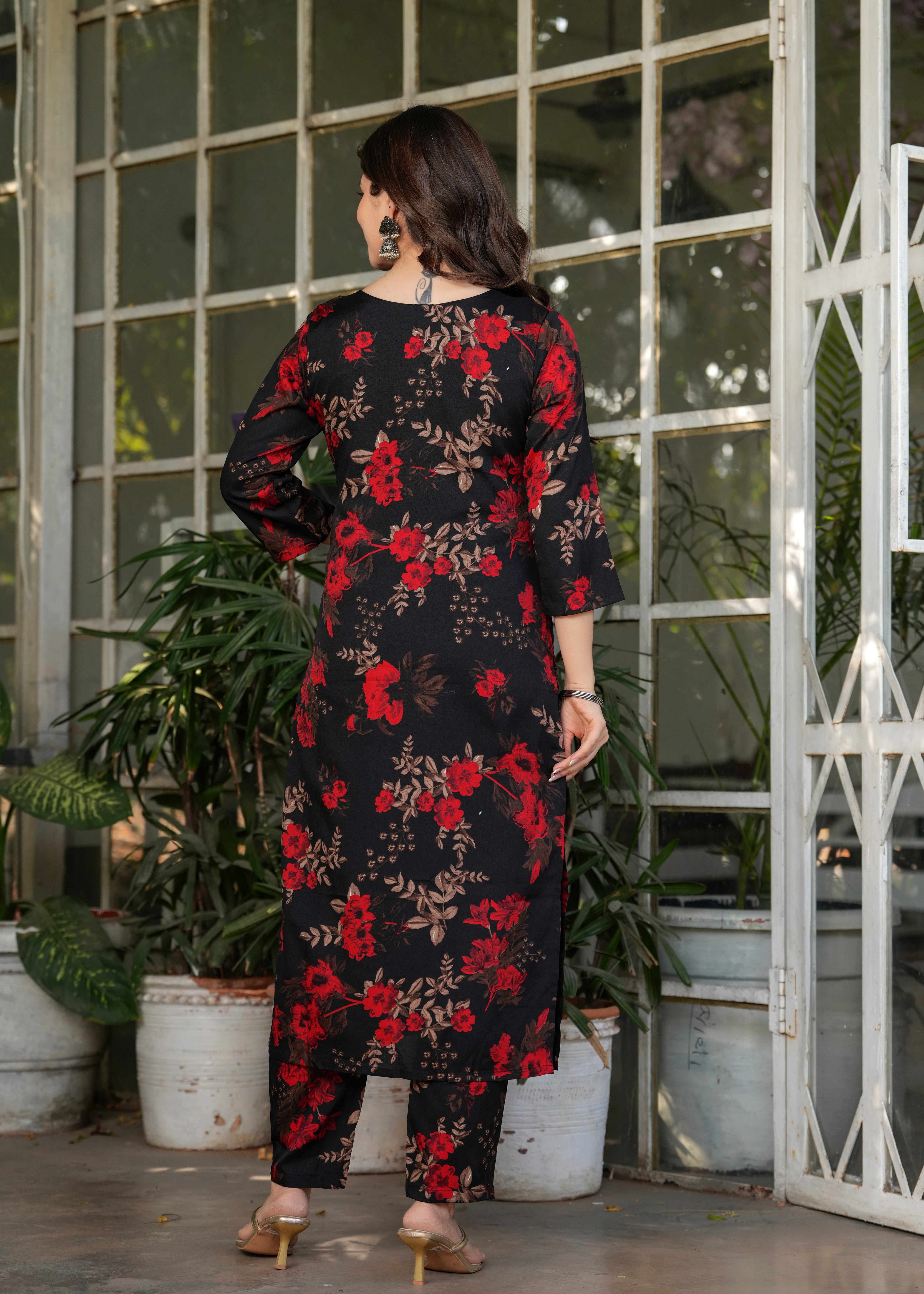 Back view of woman in black printed kurta set, displaying the straight silhouette and floral pattern.