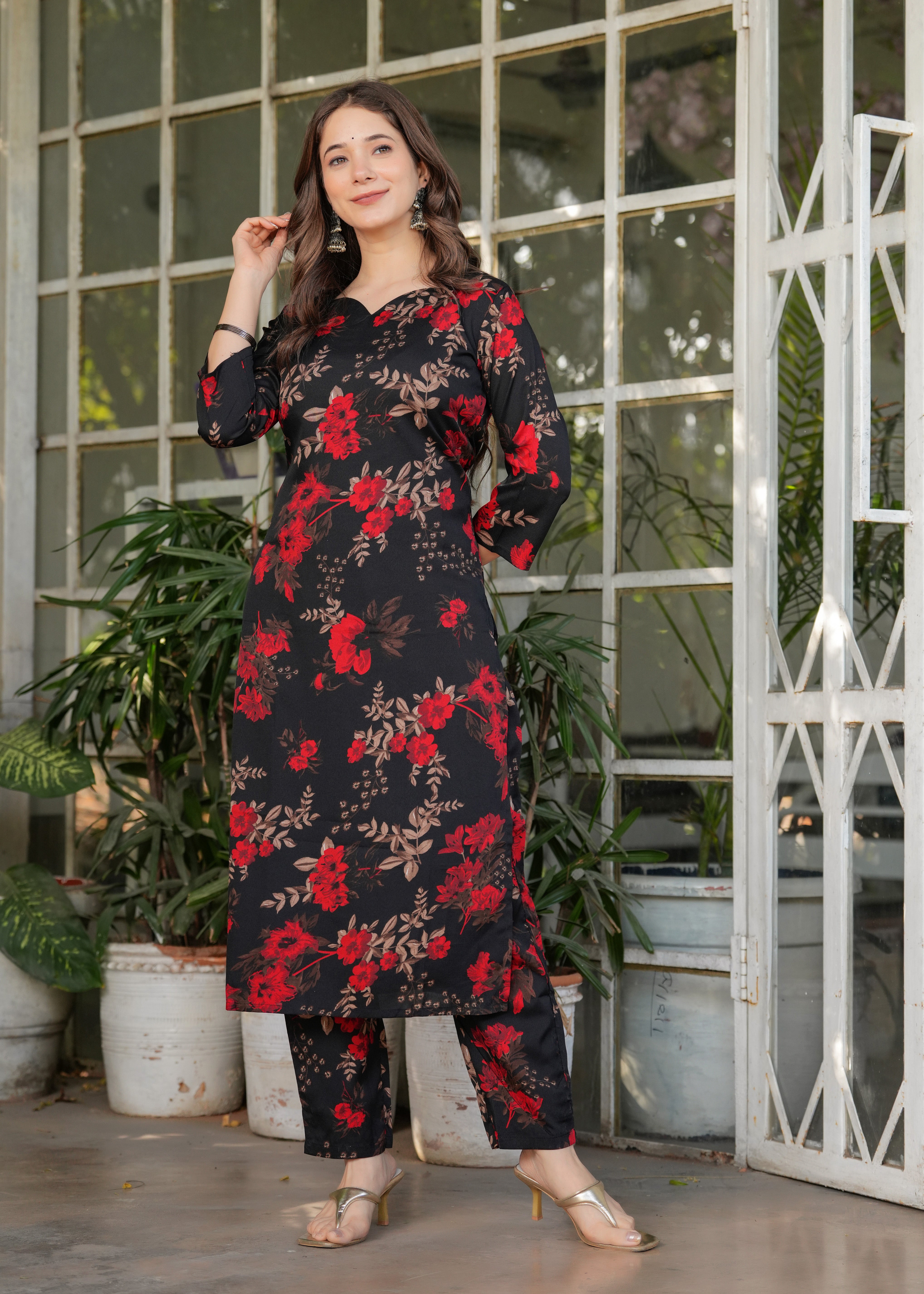 Side profile of woman in black printed ethnic wear, posing elegantly, showing kurti length.
