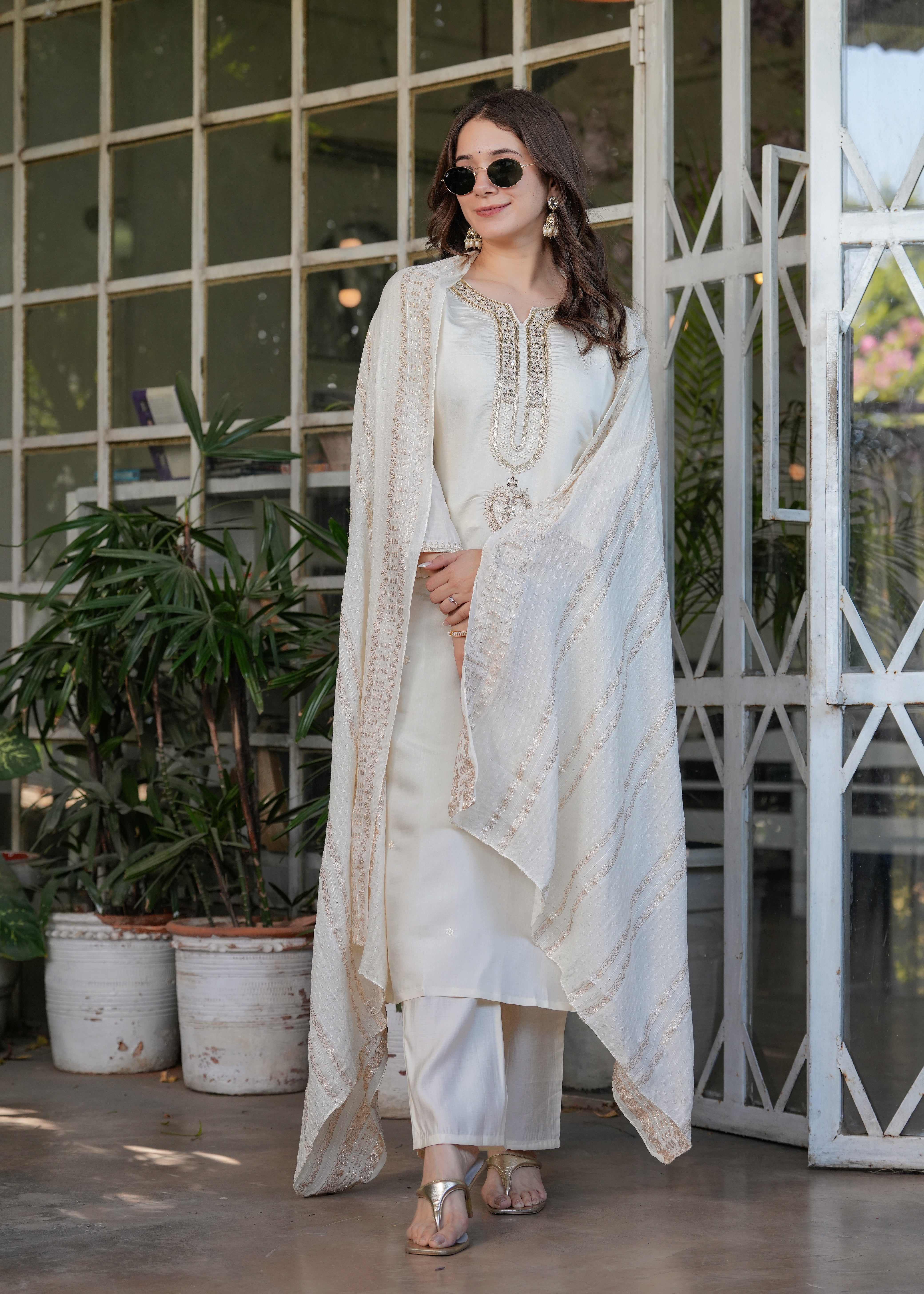 Stylish full length shot of TRENDBUY woman in off-white kurta set with sunglasses and draped dupatta