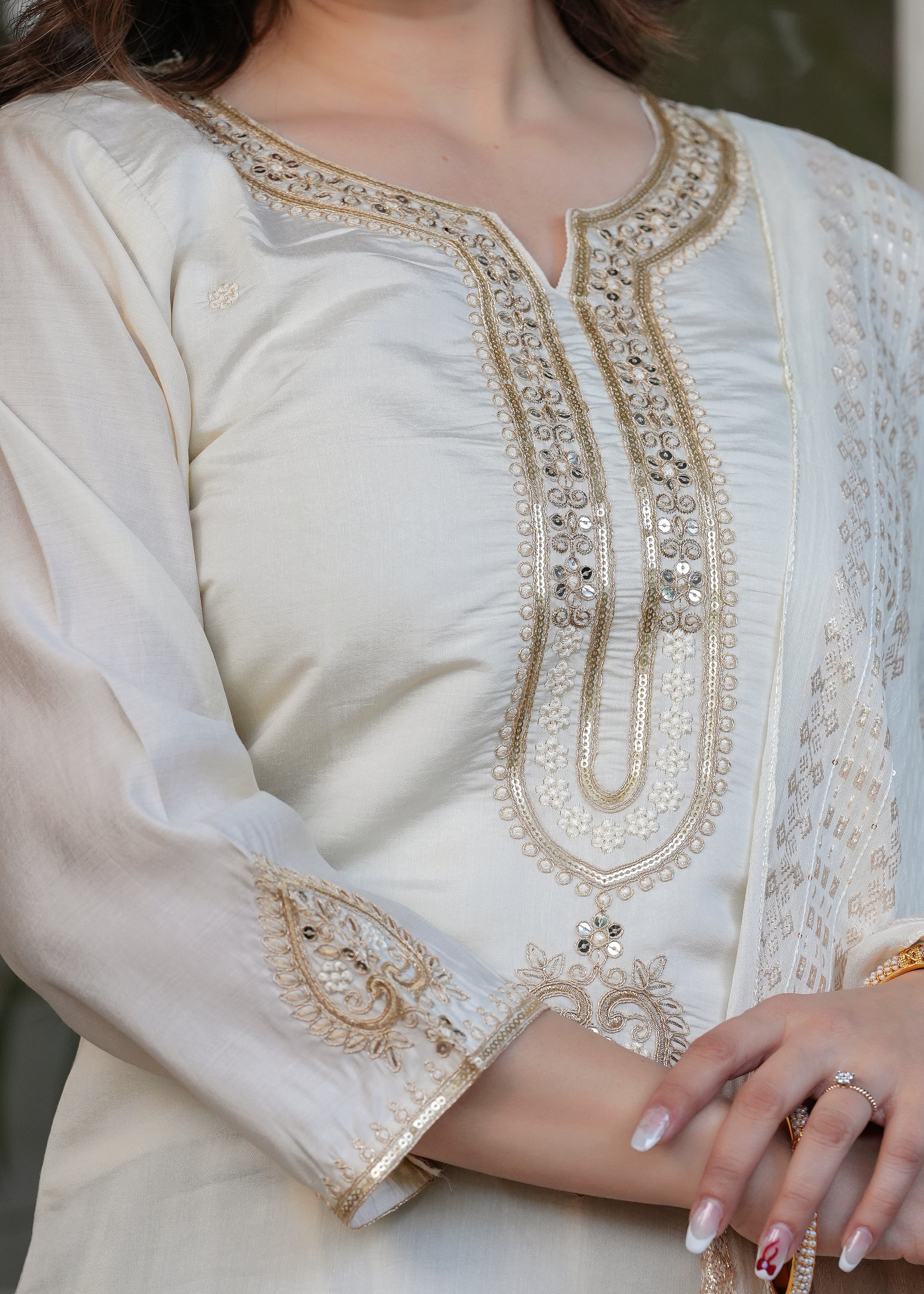 Close-up of off-white Viscose Chanderi kurta with intricate silver and gold embroidery on neckline and sequins