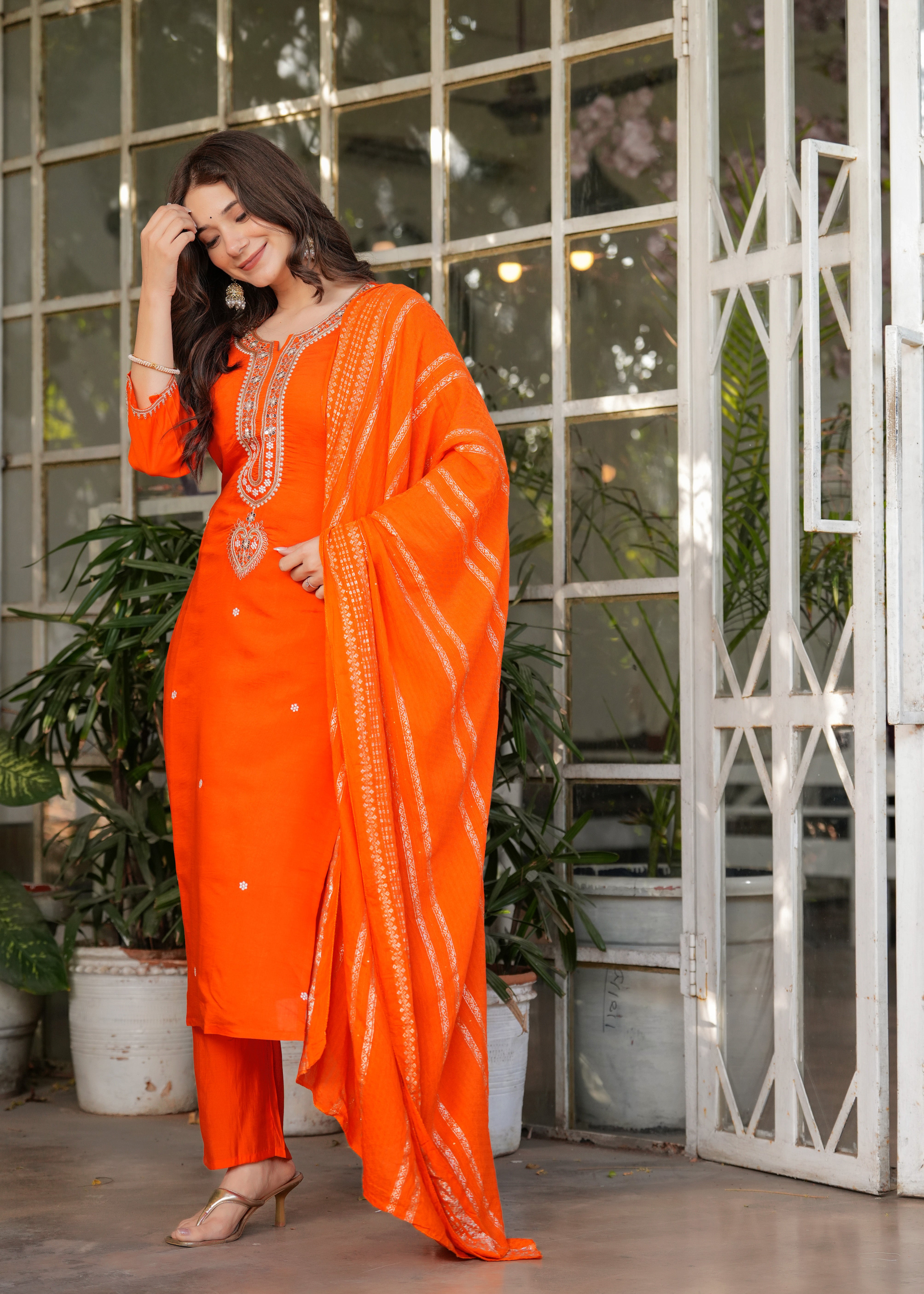 Joyful pose of TRENDBUY woman in orange kurta set, looking down