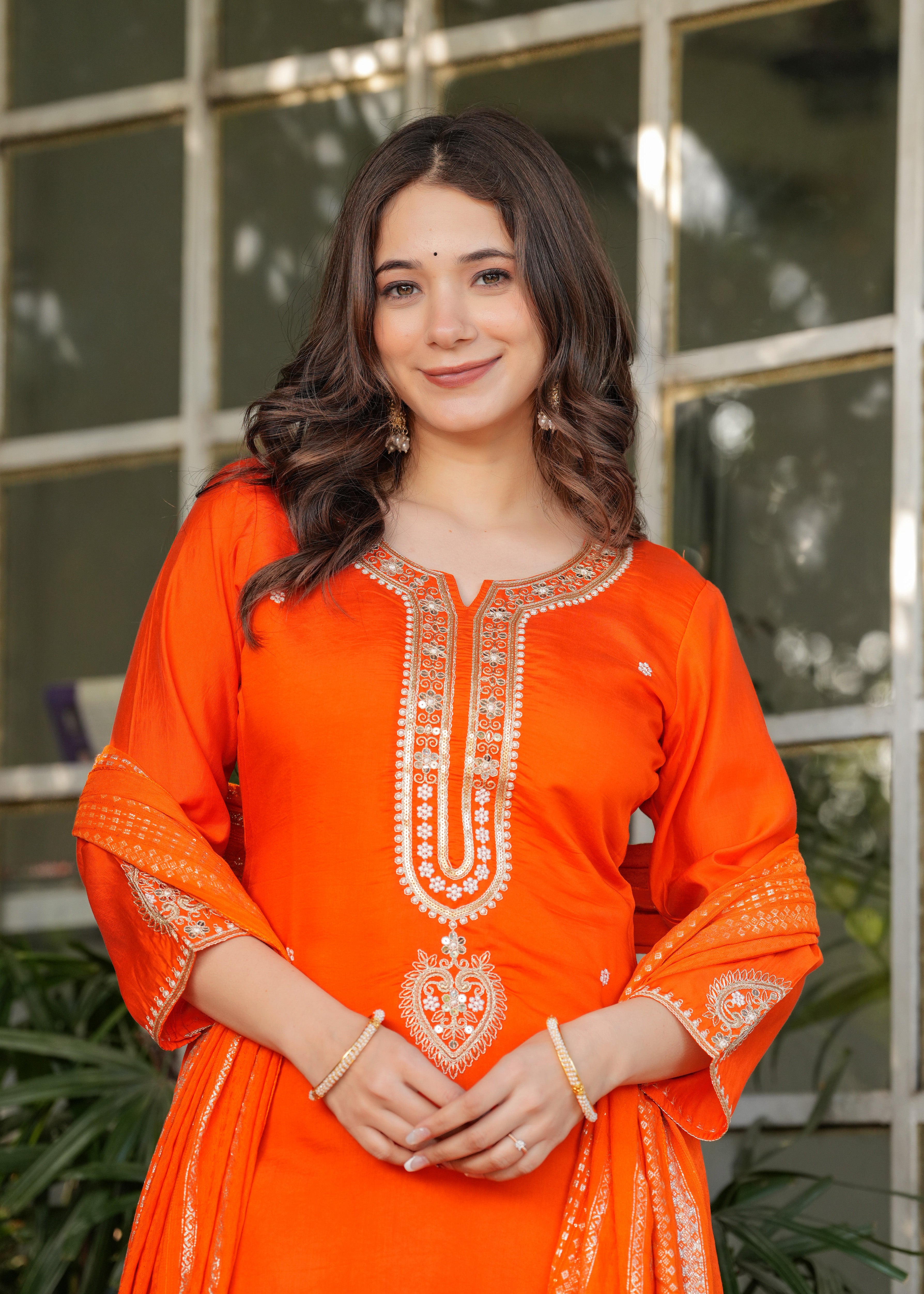 Close-up of TRENDBUY woman in orange kurta set, focusing on smile and jewelry