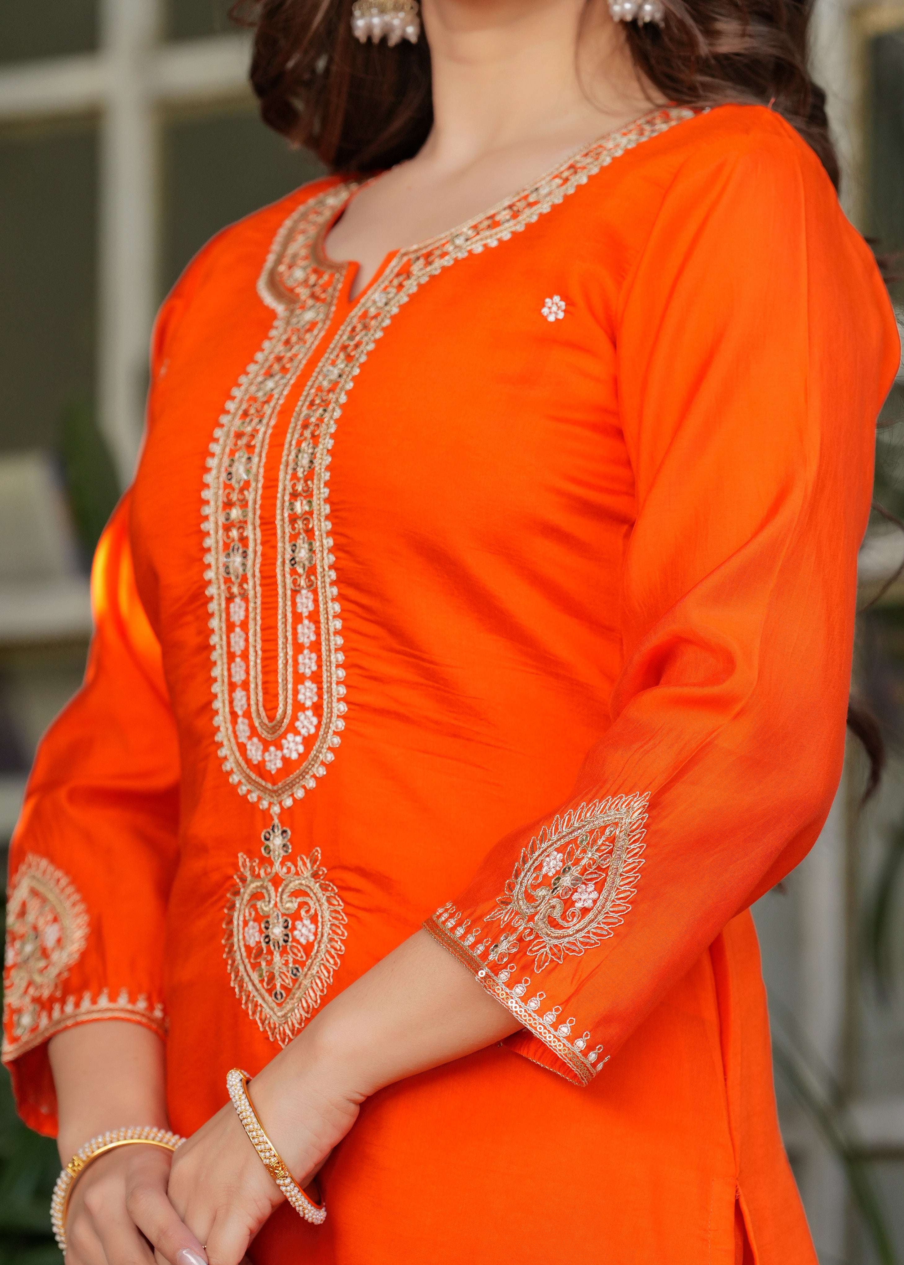 Side view close-up of orange kurta embroidery on sleeve and chest