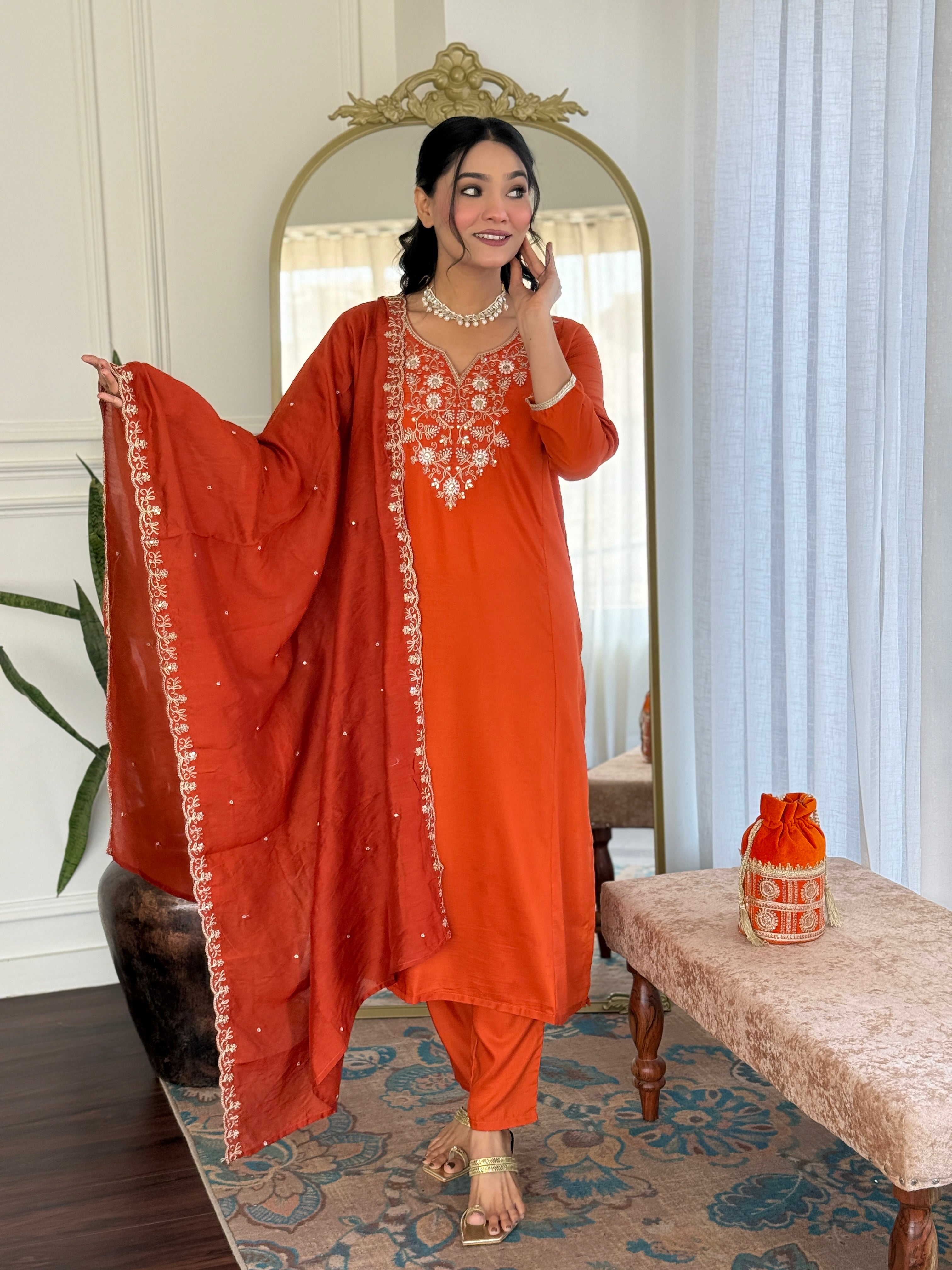 TRENDBUY model gracefully spreading the embroidered Chanderi Cotton dupatta of the orange kurta set, displaying its intricate border work.