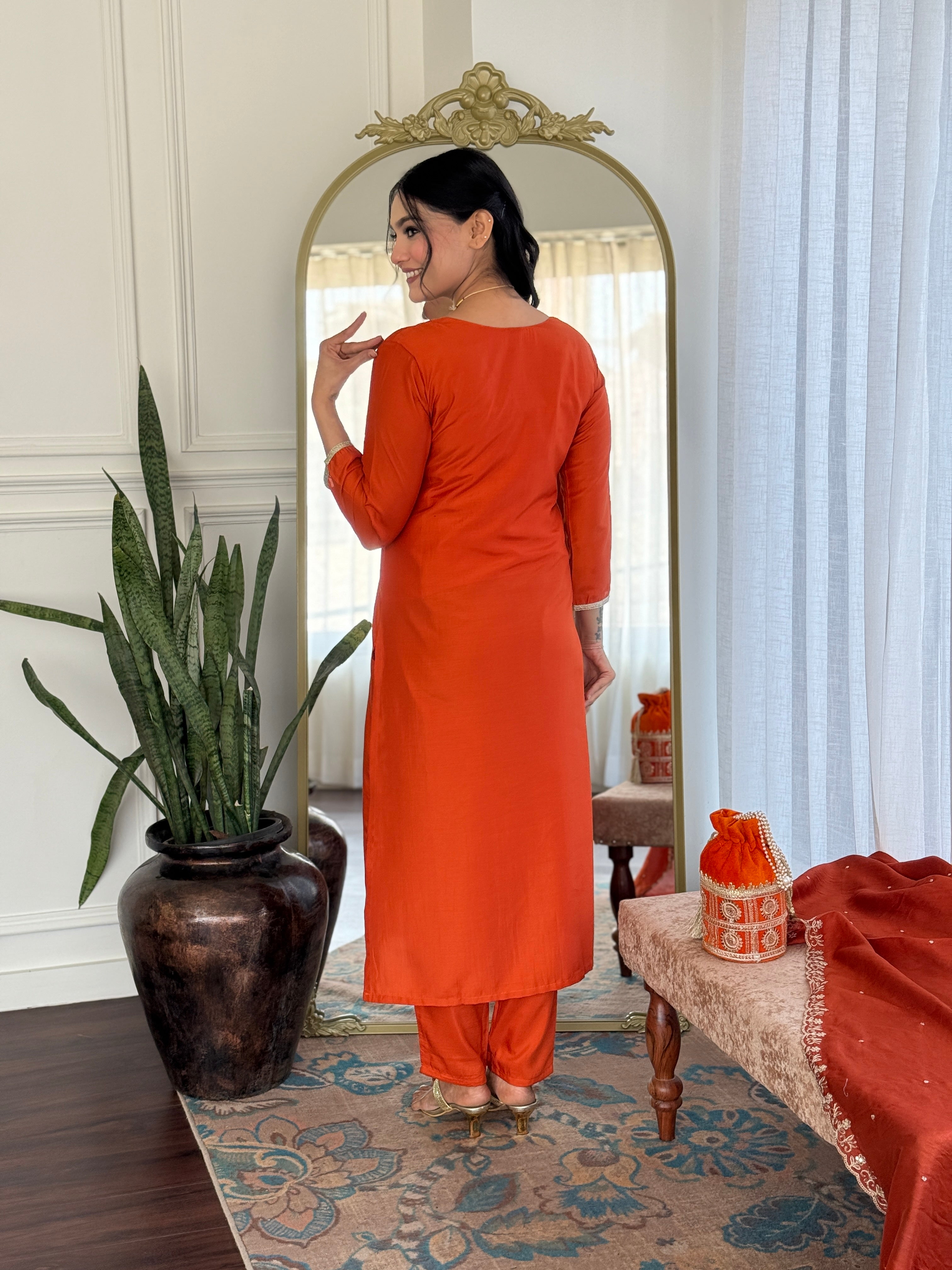 Back view of the TRENDBUY model wearing the orange kurta set, emphasizing the clean lines and elegant drape of the outfit.