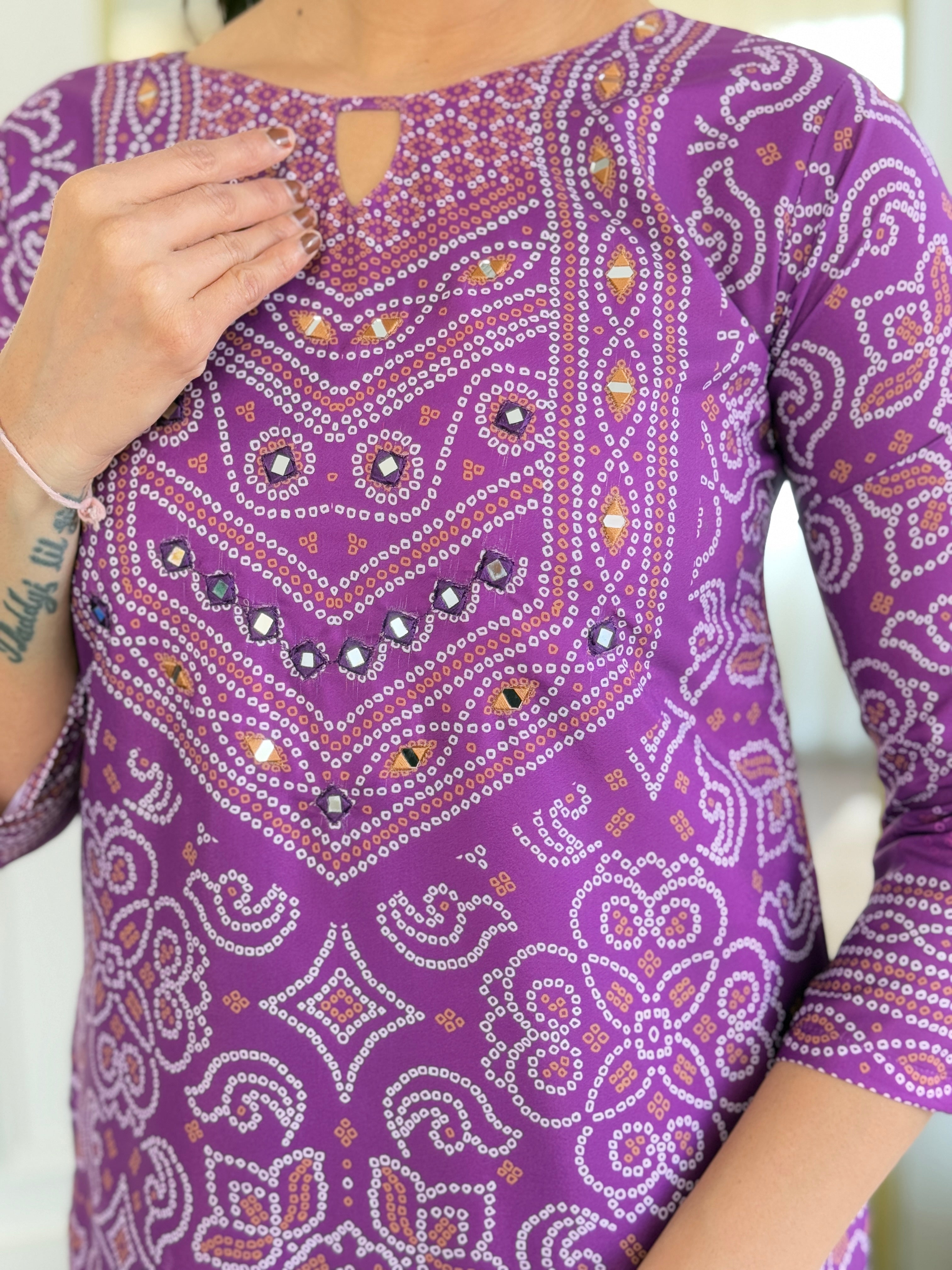 Macro shot of the exquisite hand mirror work and patterned design on the purple Franch Crepe kurti bodice.
