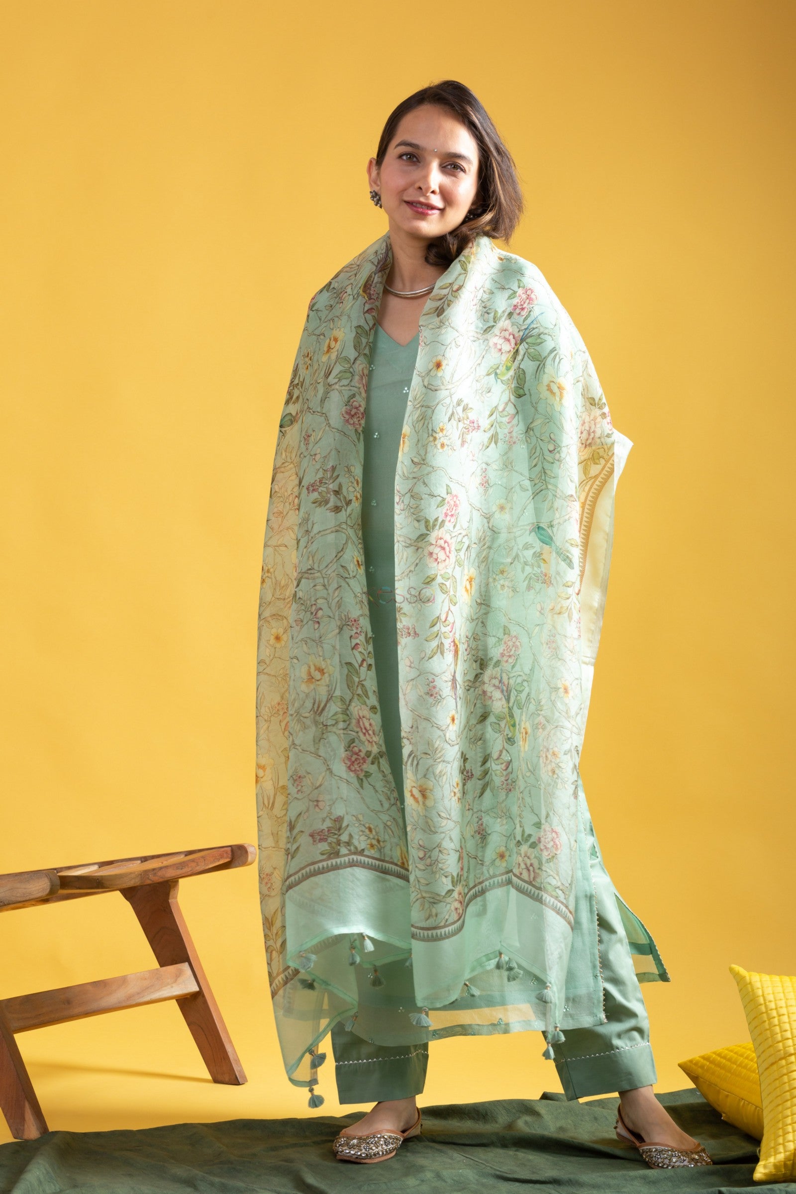 Woman posing gracefully in a complete mint green embroidered kurta set, with the floral dupatta draped over her shoulders.