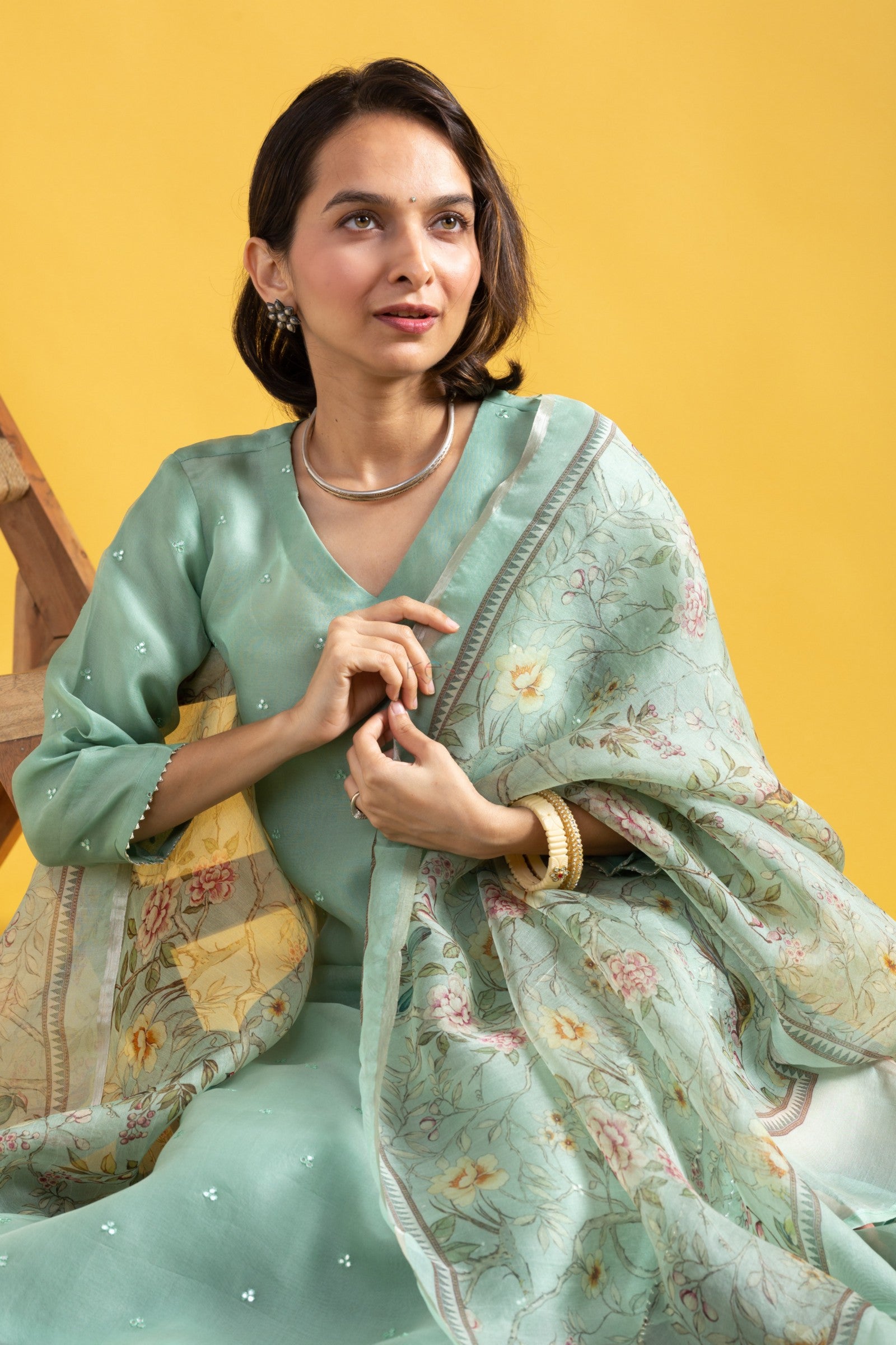 Close-up of woman in mint green Viscose Chanderi kurta, showcasing the intricate embroidery on the neckline and sleeves, and the floral Tabby Organza dupatta.