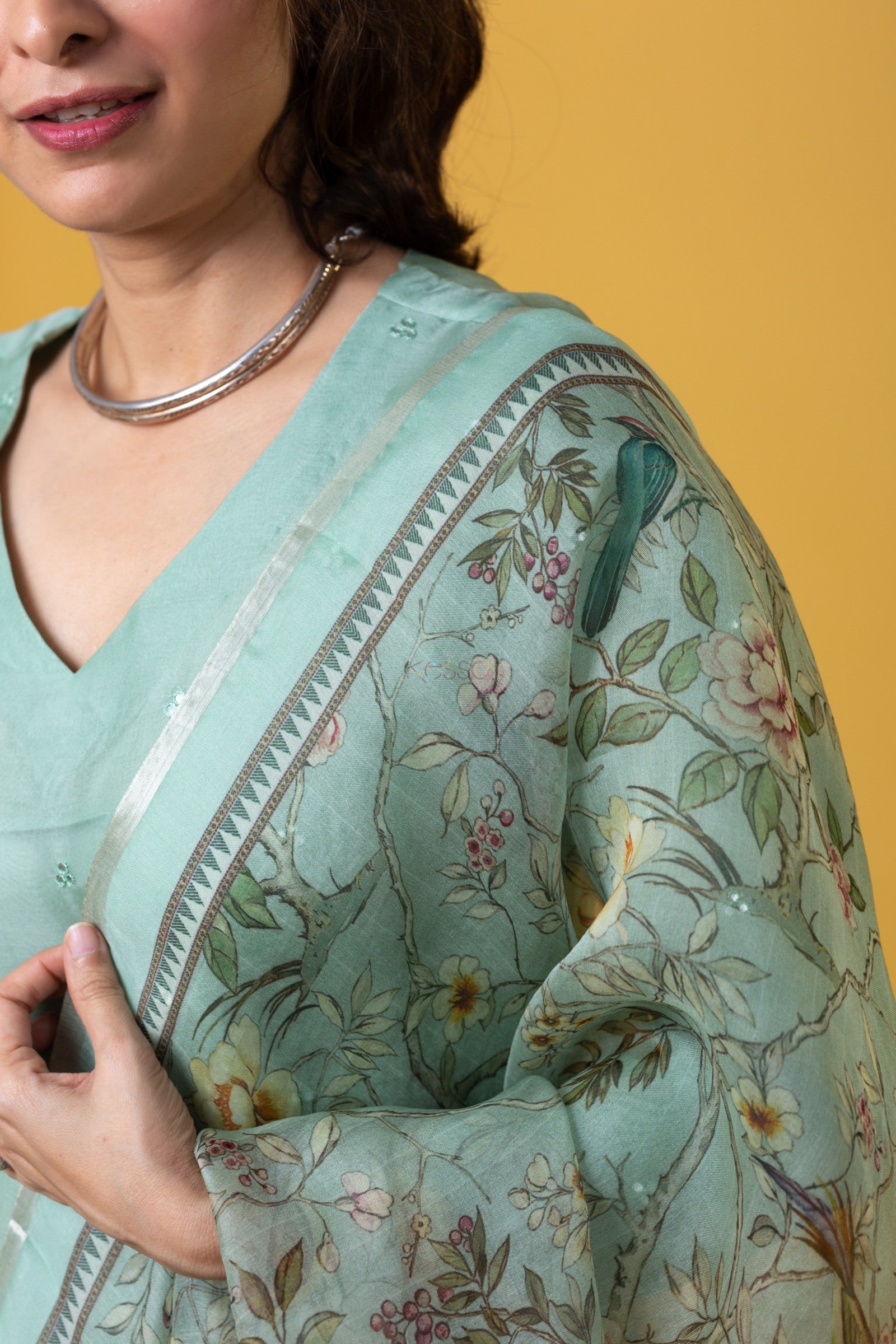 Close-up detail of the mint green embroidered kurta fabric texture and the beautiful floral print of the Tabby Organza dupatta.