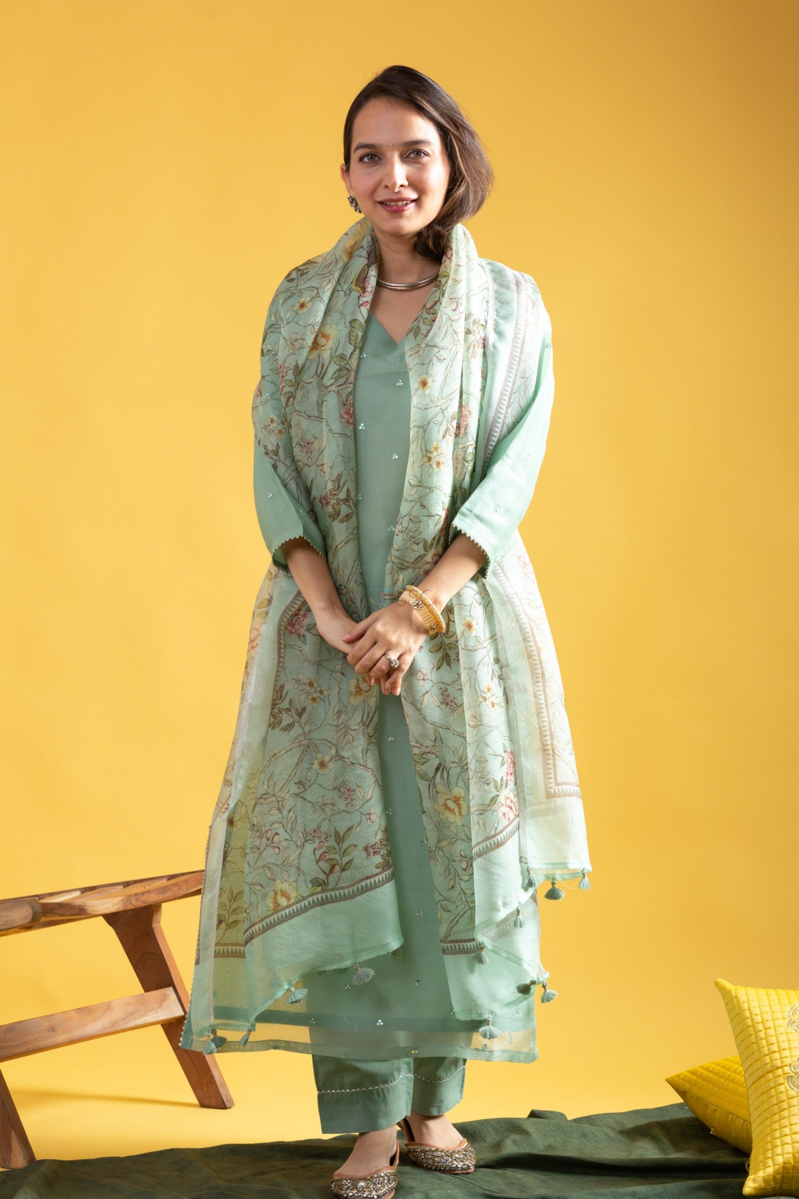 Full shot of woman in a sophisticated mint green kurta set, hands clasped, highlighting the overall elegance of the ethnic ensemble.