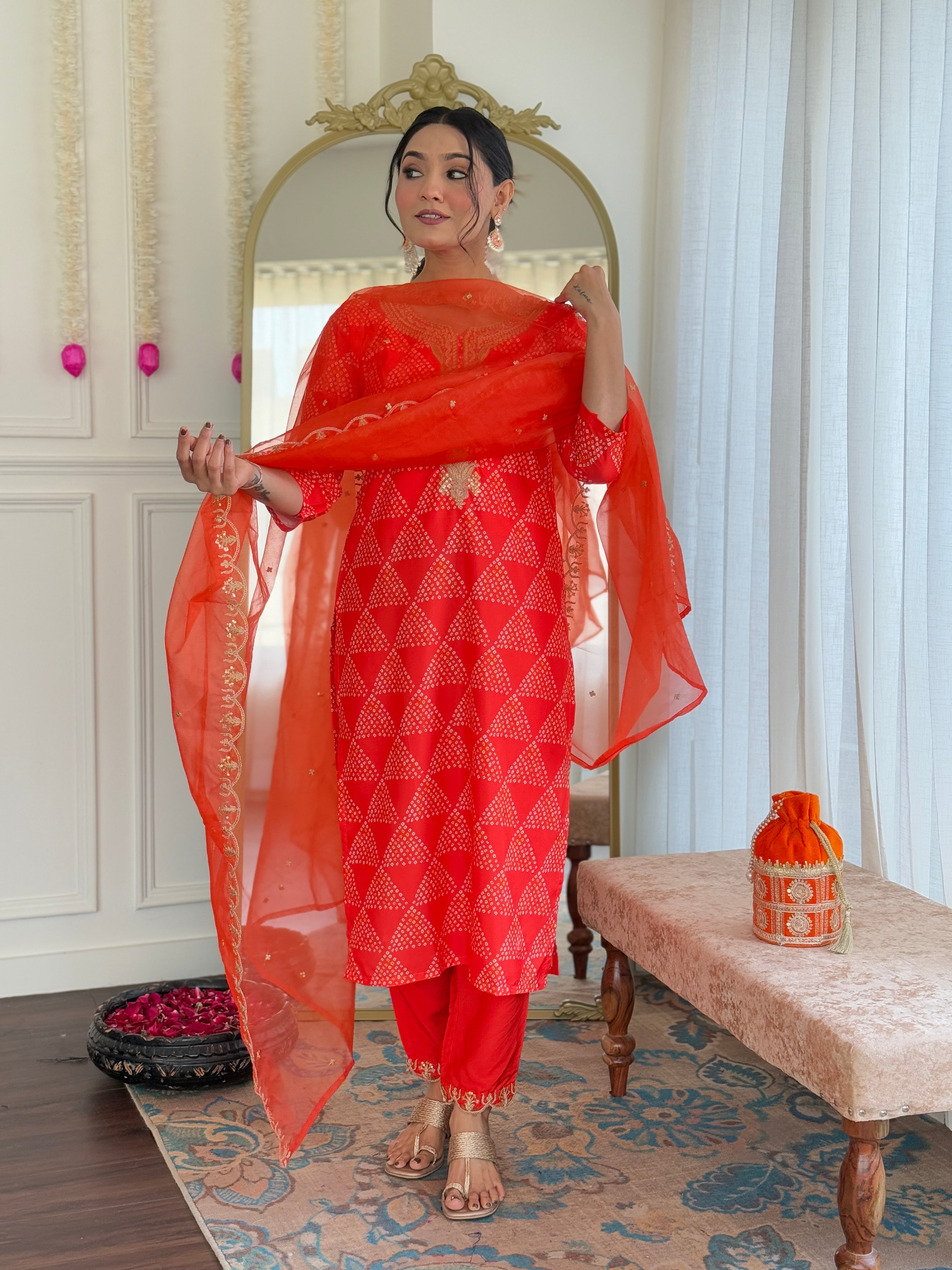 Woman displaying the lightweight and sheer elegance of the orange organza dupatta, with gold embellished border.