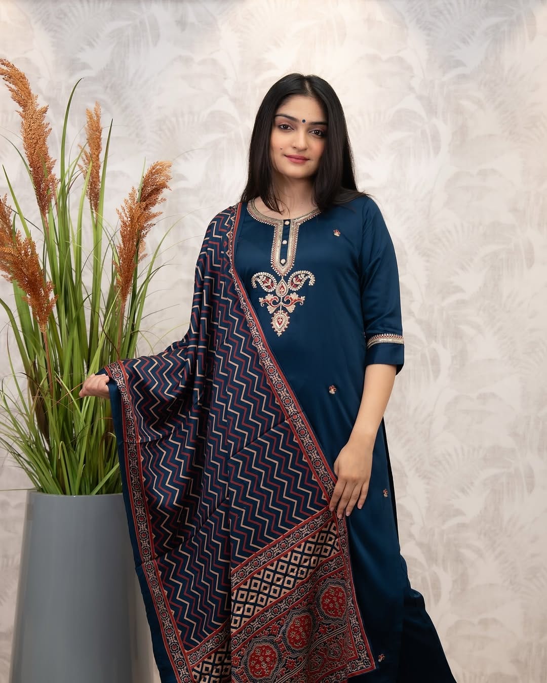 Woman in deep blue Chanderi Silk Kurta Set, posing elegantly with the intricately patterned muslin dupatta draped