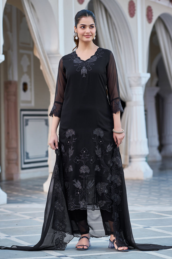 Model showcasing black Fox Blooming Georgette kurti set with intricate embroidery and matching dupatta in an outdoor setting.