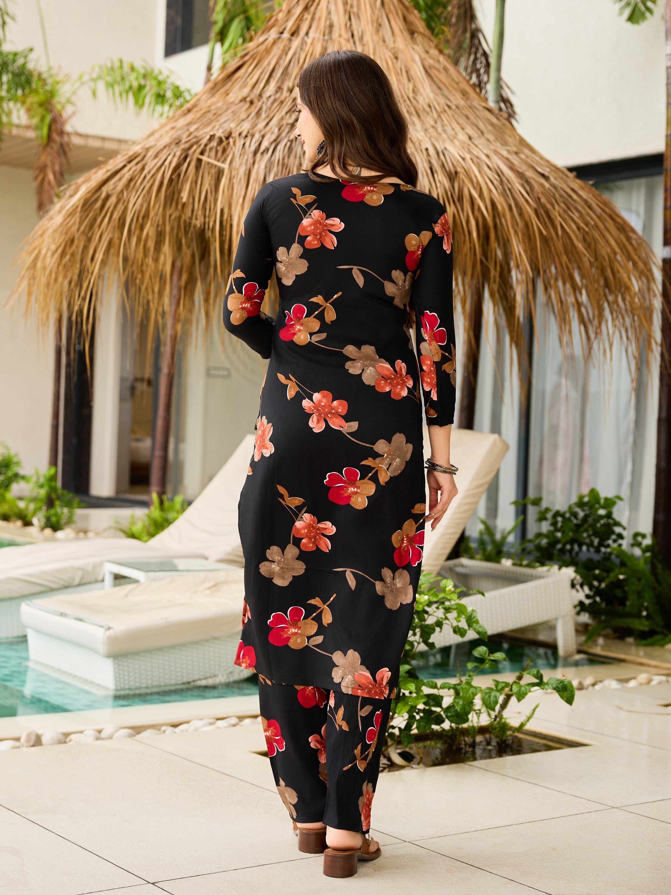 Back view of TRENDBUY black floral kurti and pant set, showing long kurta length and elegant fit near a pool