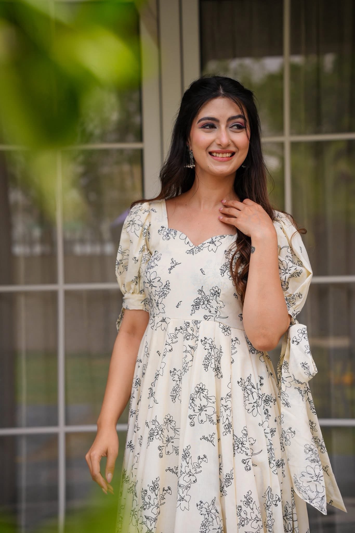 Close-up of a woman smiling, featuring the sweetheart neckline and puff sleeves of the cream floral dress