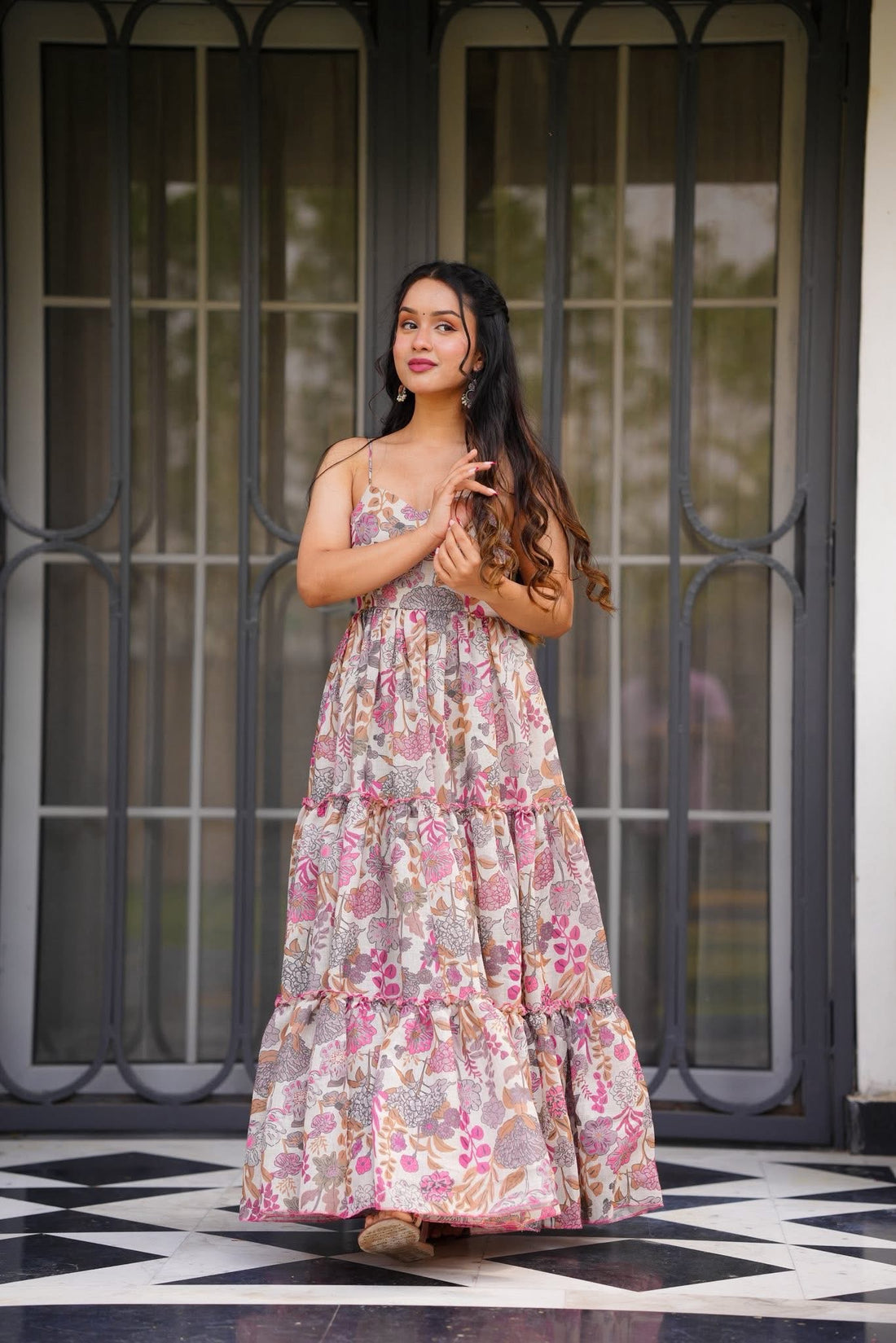 Elegant woman posing sideways, gracefully adjusting her hands, wearing a comfortable floral print tiered maxi dress from TRENDBUY.