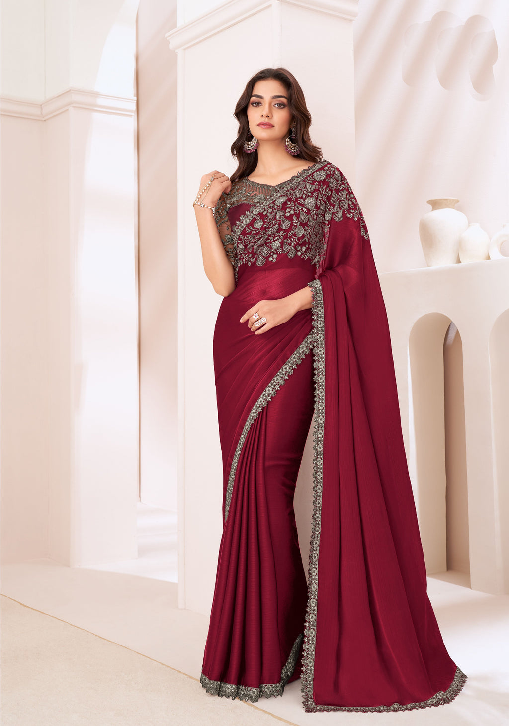 Model wearing elegant maroon partywear saree with a stylish designer blouse.