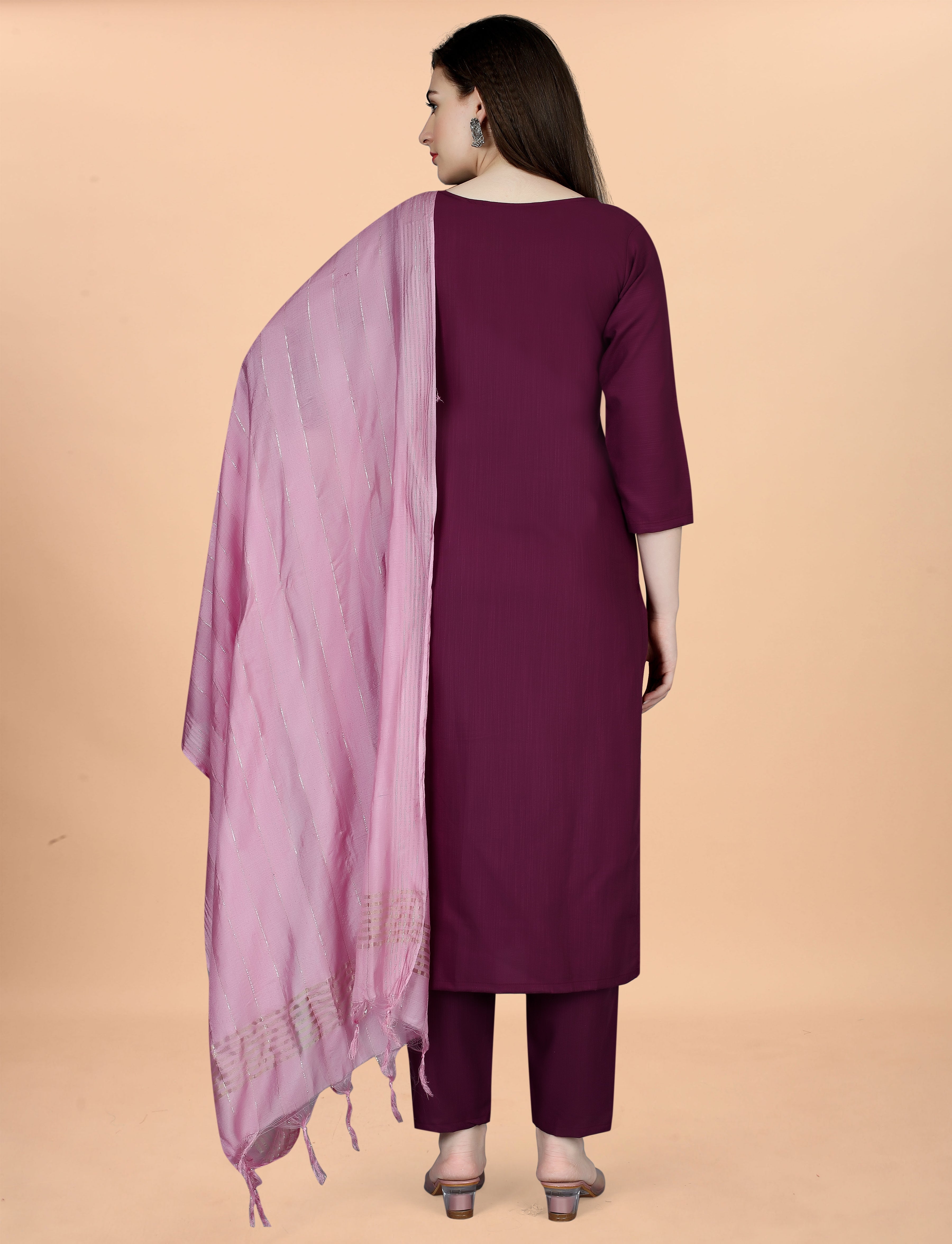 Back view of a woman wearing a plum embroidered cotton blend kurti, matching pant, and a light pink chanderi dupatta draped over her shoulder.