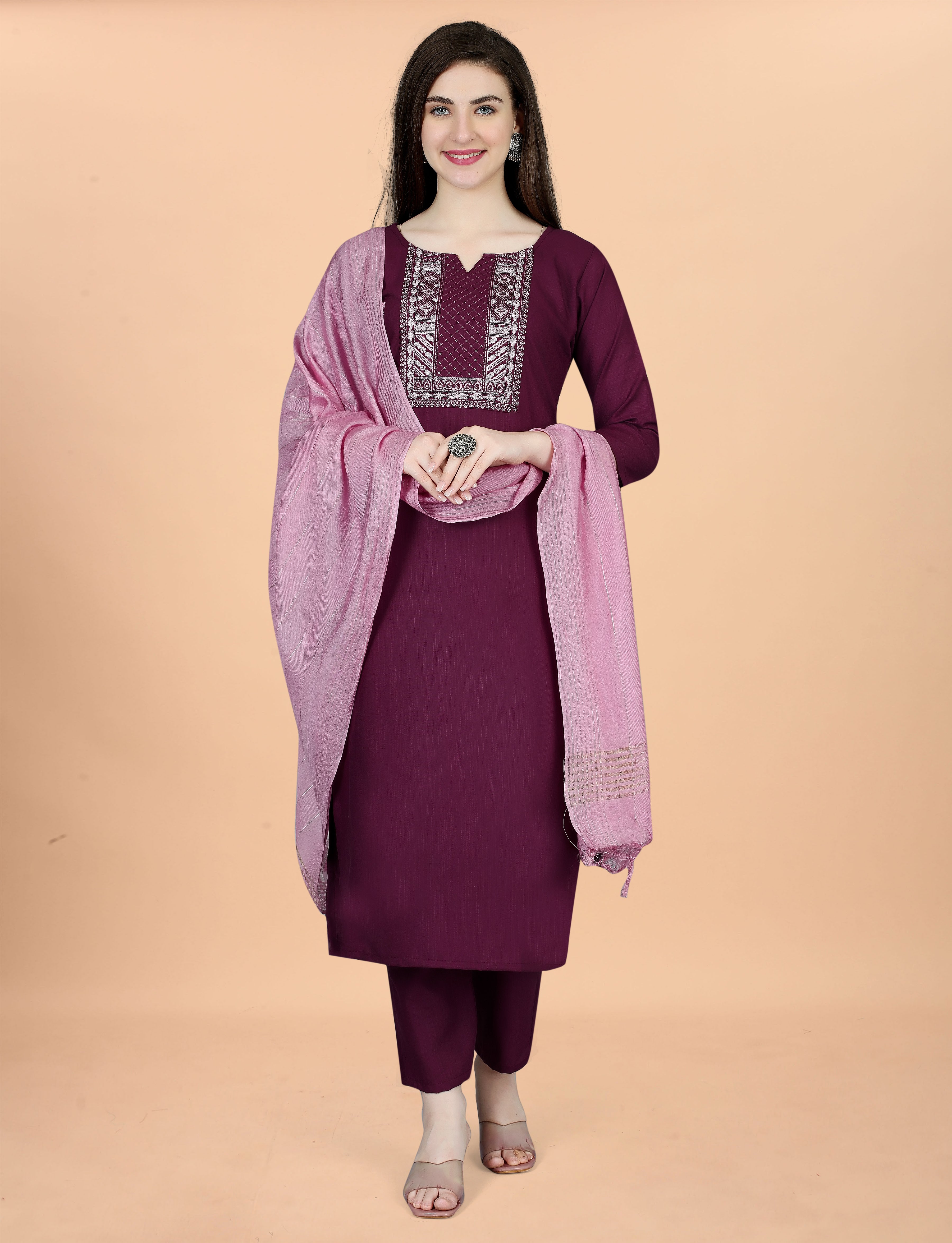Full front view of a woman with hands clasped, elegantly presenting the plum embroidered kurti, pant, and light pink chanderi dupatta.