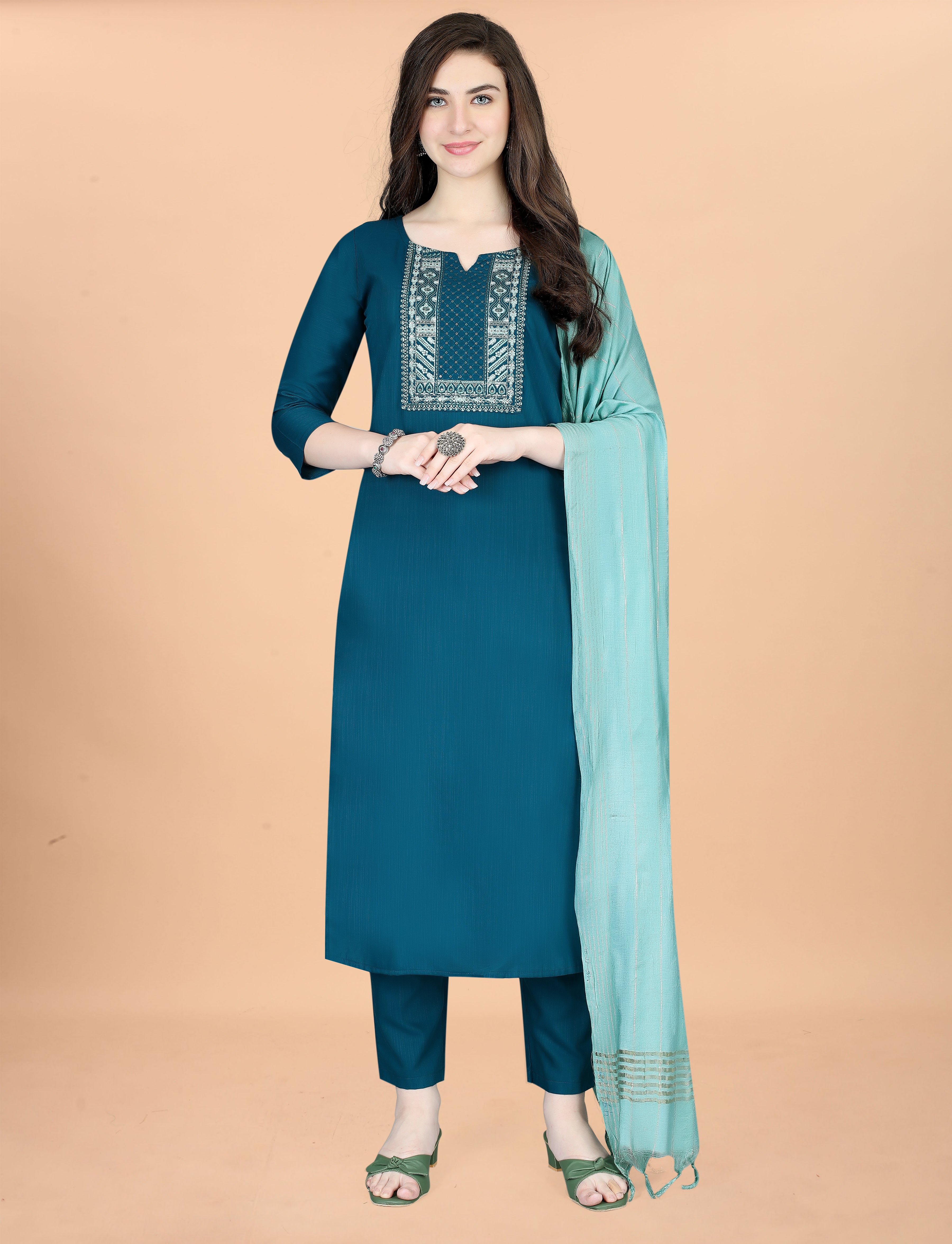 Front view of a woman smiling in a teal embroidered cotton blend kurti, comfortable pant, and an elegant mint green chanderi dupatta.