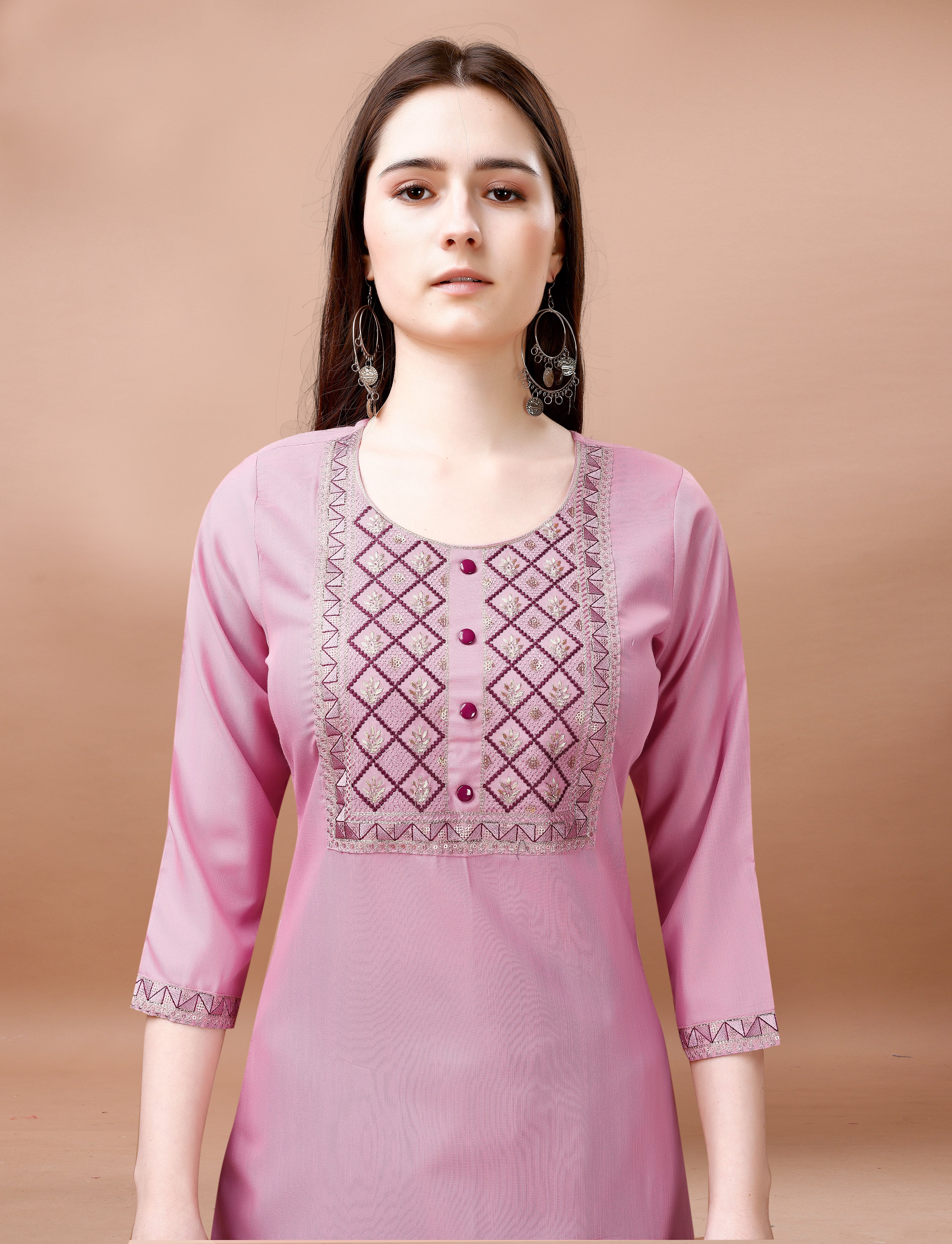 Close-up of a woman's upper body, highlighting the elaborate geometric embroidery on the neckline and sleeves of a blush pink cotton blend kurti.