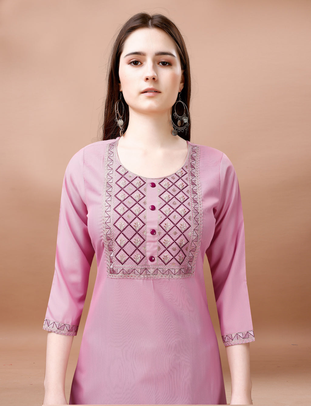 Close-up of a woman's upper body, highlighting the elaborate geometric embroidery on the neckline and sleeves of a blush pink cotton blend kurti.