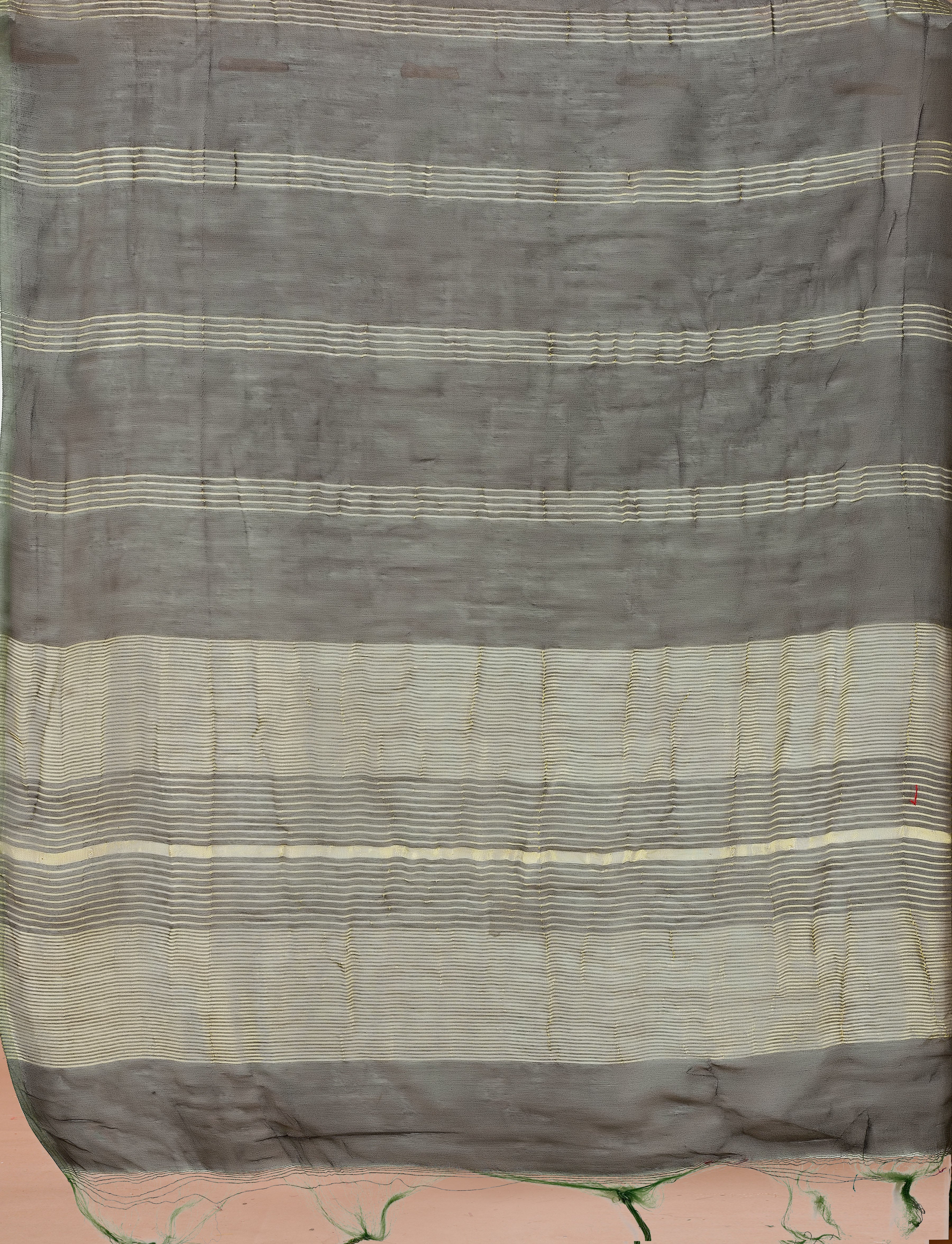 Close-up of a charcoal grey Chanderi dupatta with subtle golden horizontal stripe patterns and tassels.